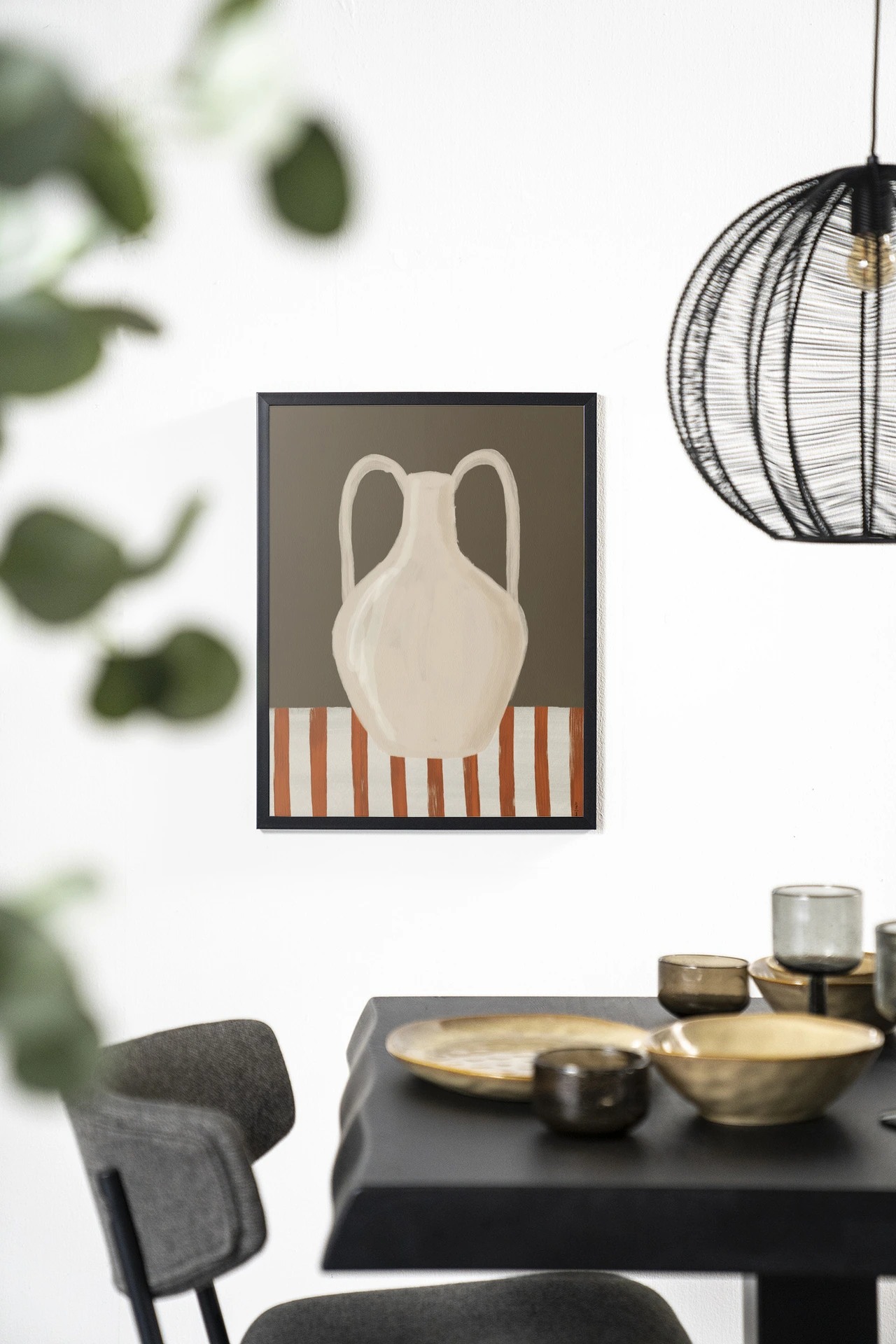 Wandkleed Vivid Vase 06 - Urban Cotton hangt aan een witte muur boven een zwarte tafel