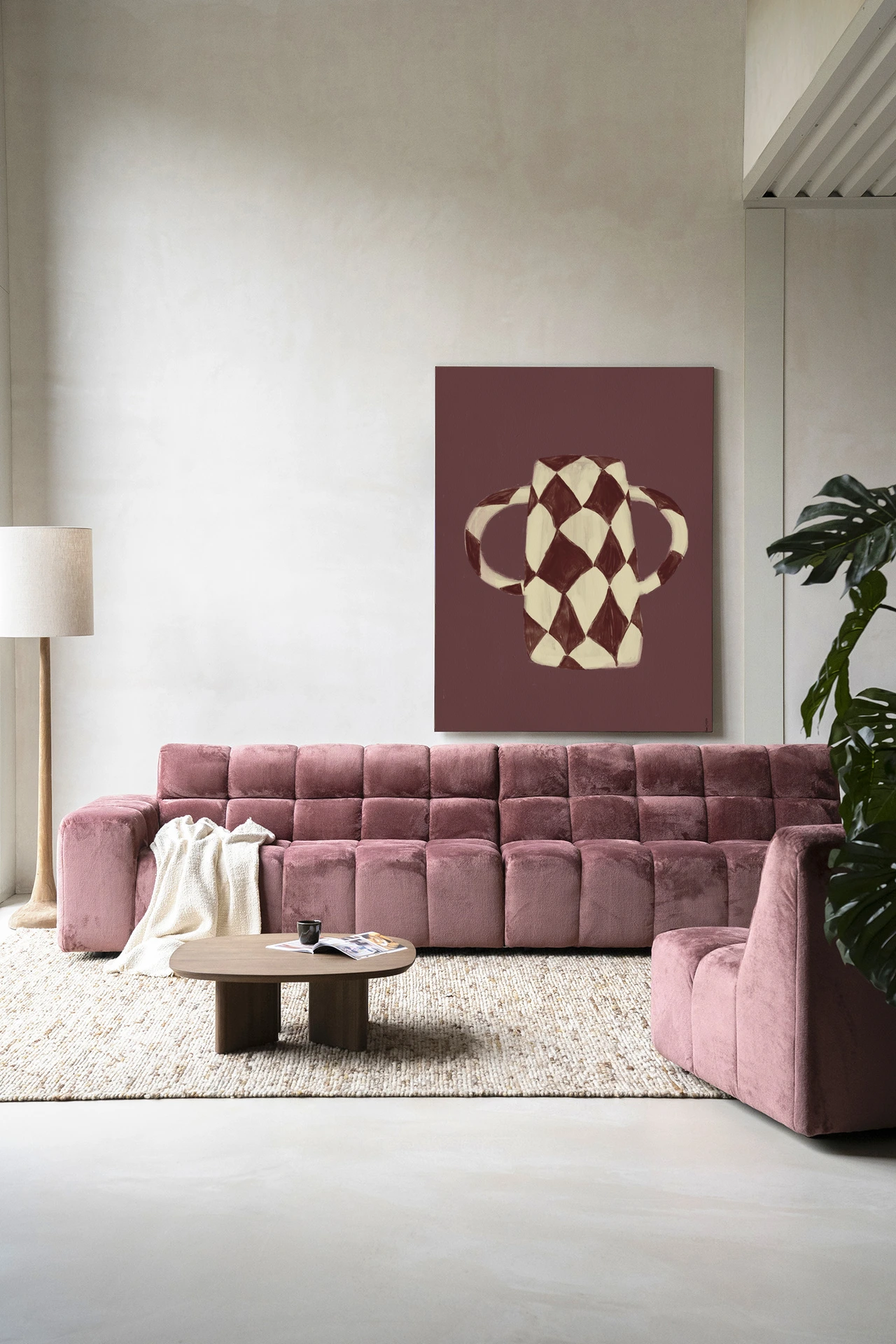 Wandkleed Vivid Vase 07 van Urban Cotton hangt boven een roze bank in een moderne woonkamer