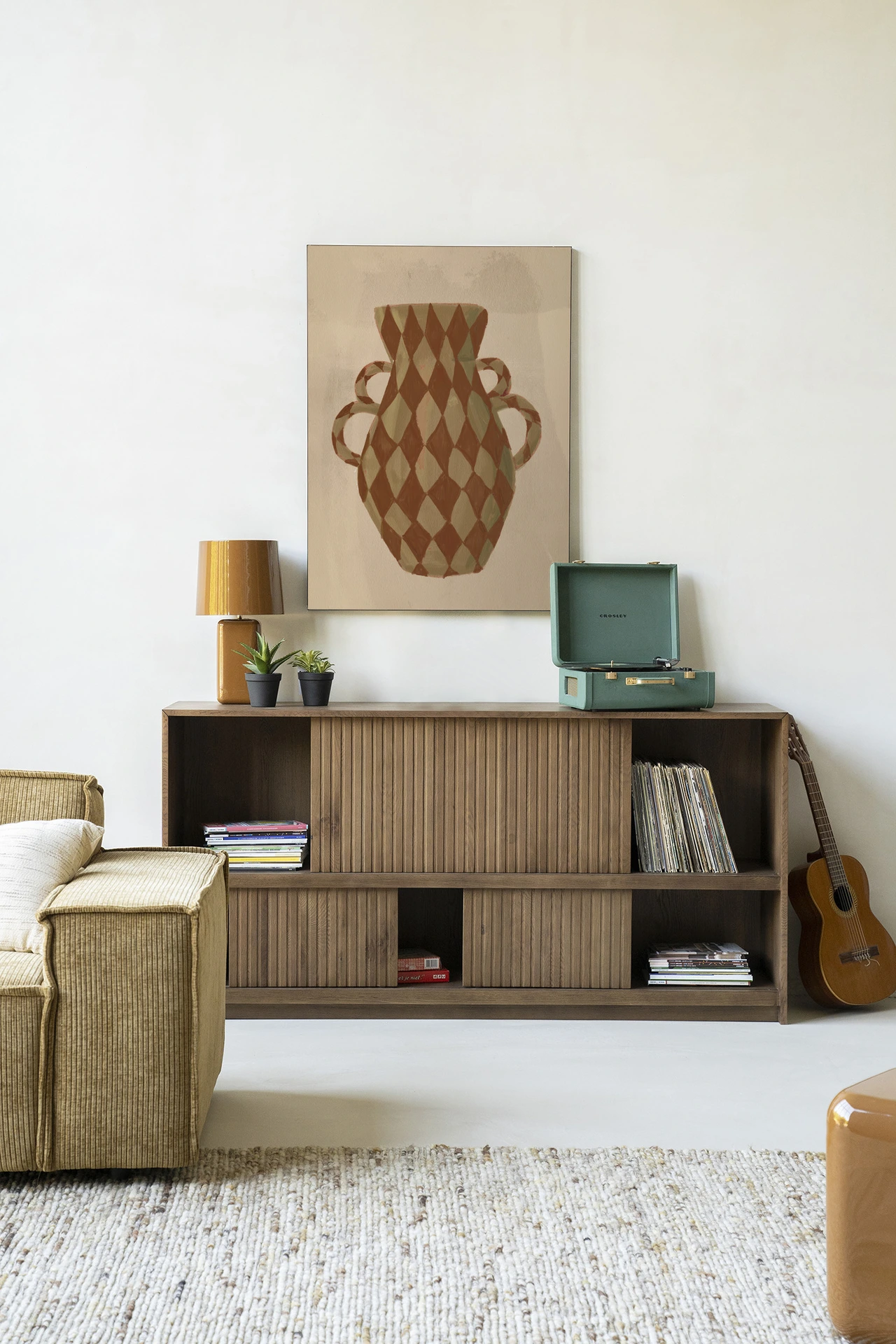 Wandkleed Vivid Vase 08 - Urban Cotton hangend boven een houten dressoir in een modern interieur