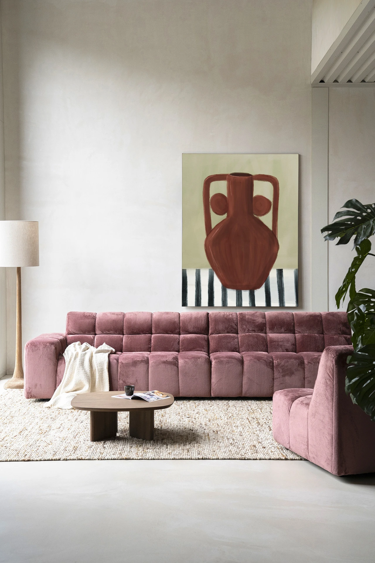 Wandkleed Vivid Vase 10 - Urban Cotton hangend boven een roze bank in een moderne woonkamer