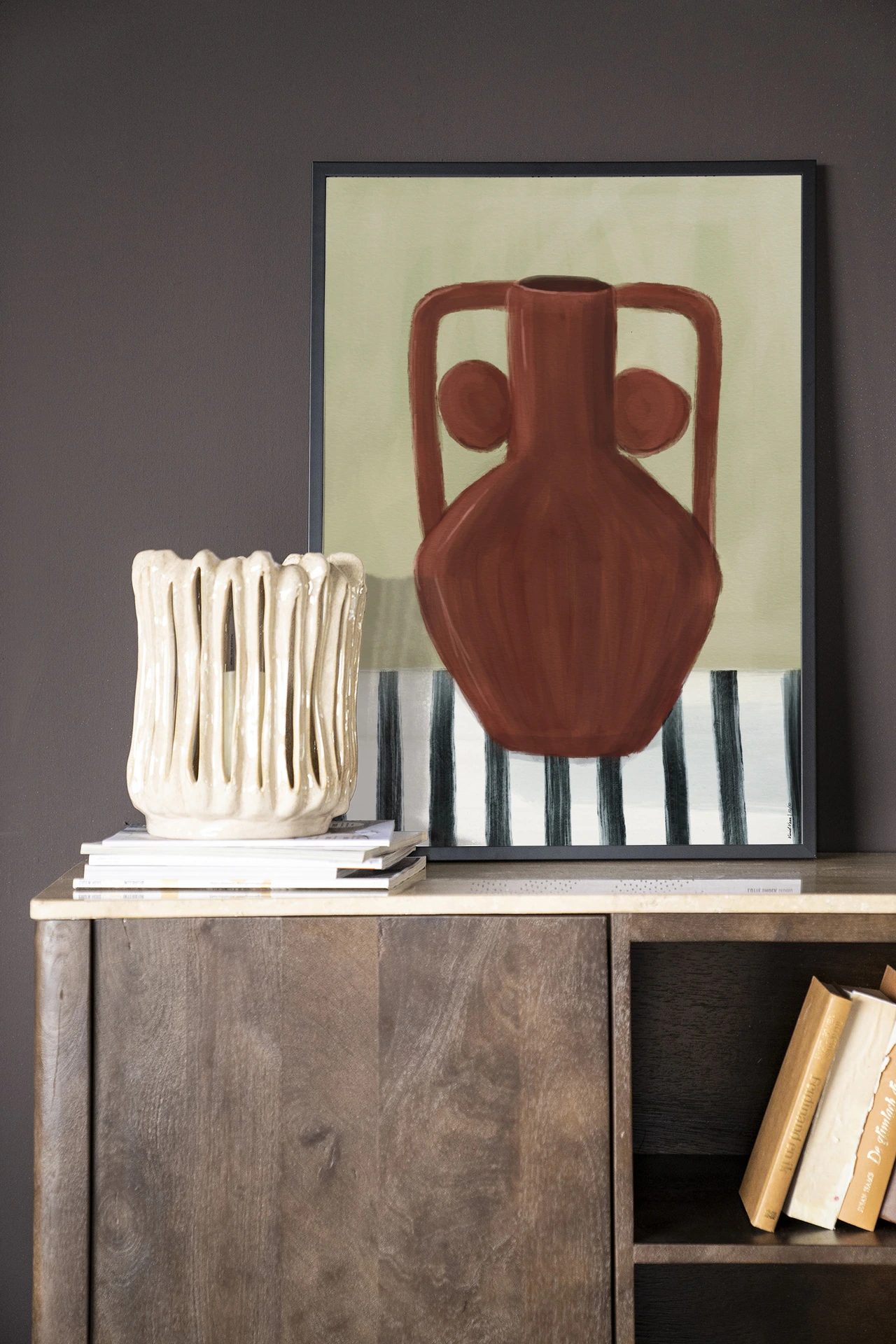 Wandkleed Vivid Vase 10 - Urban Cotton in een lijst, staand op een houten dressoir met een vaas ernaast