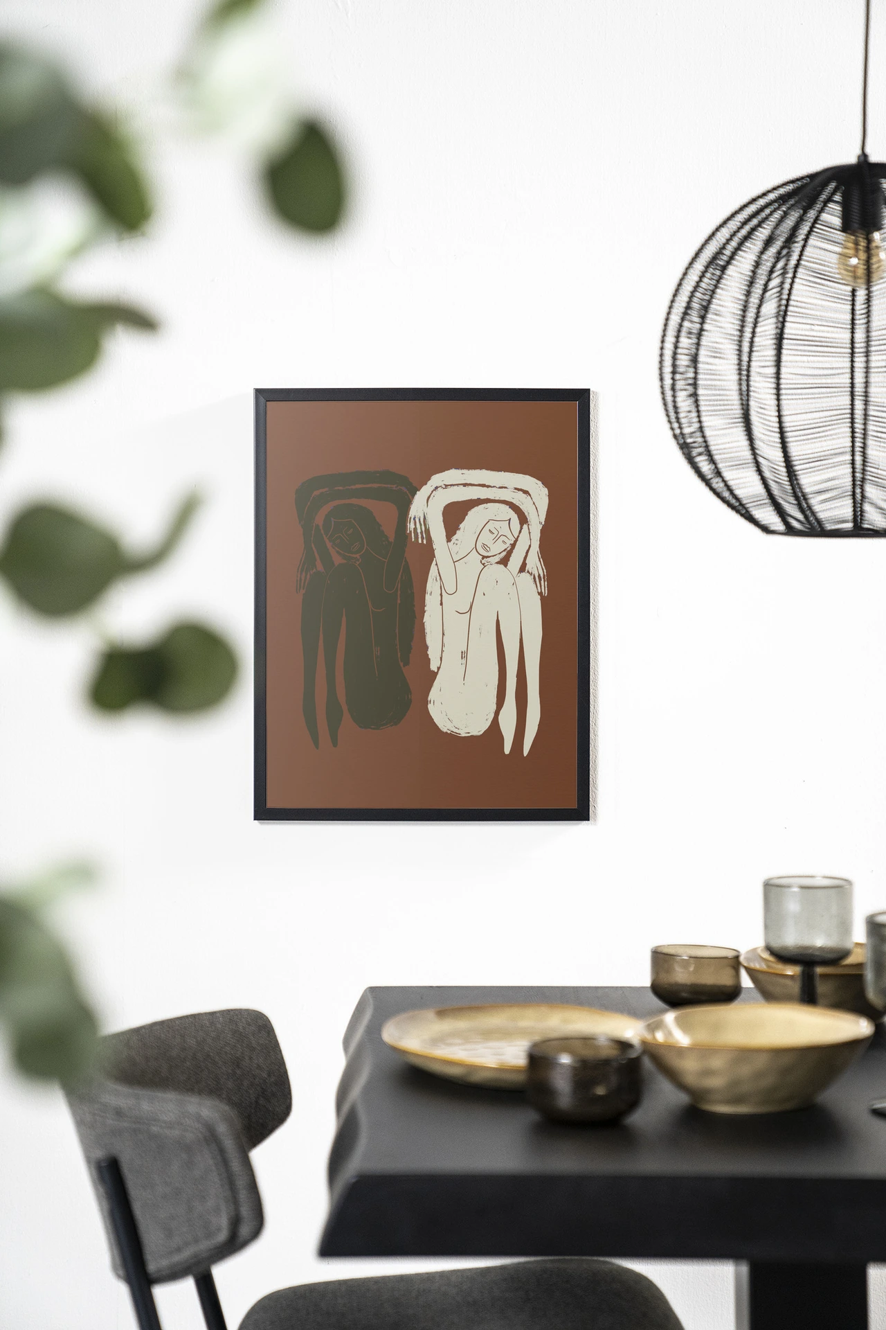 Wandkleed Bound Together - Urban Cotton hangt aan een witte muur boven een zwarte tafel
