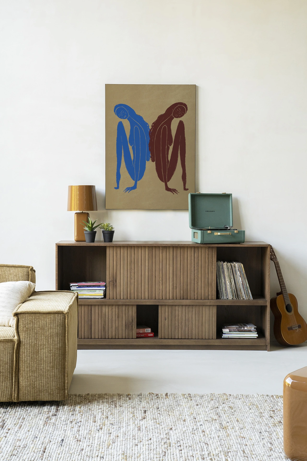 Wandkleed Sync Motion - Urban Cotton hangt boven een houten dressoir met een platenspeler en gitaar