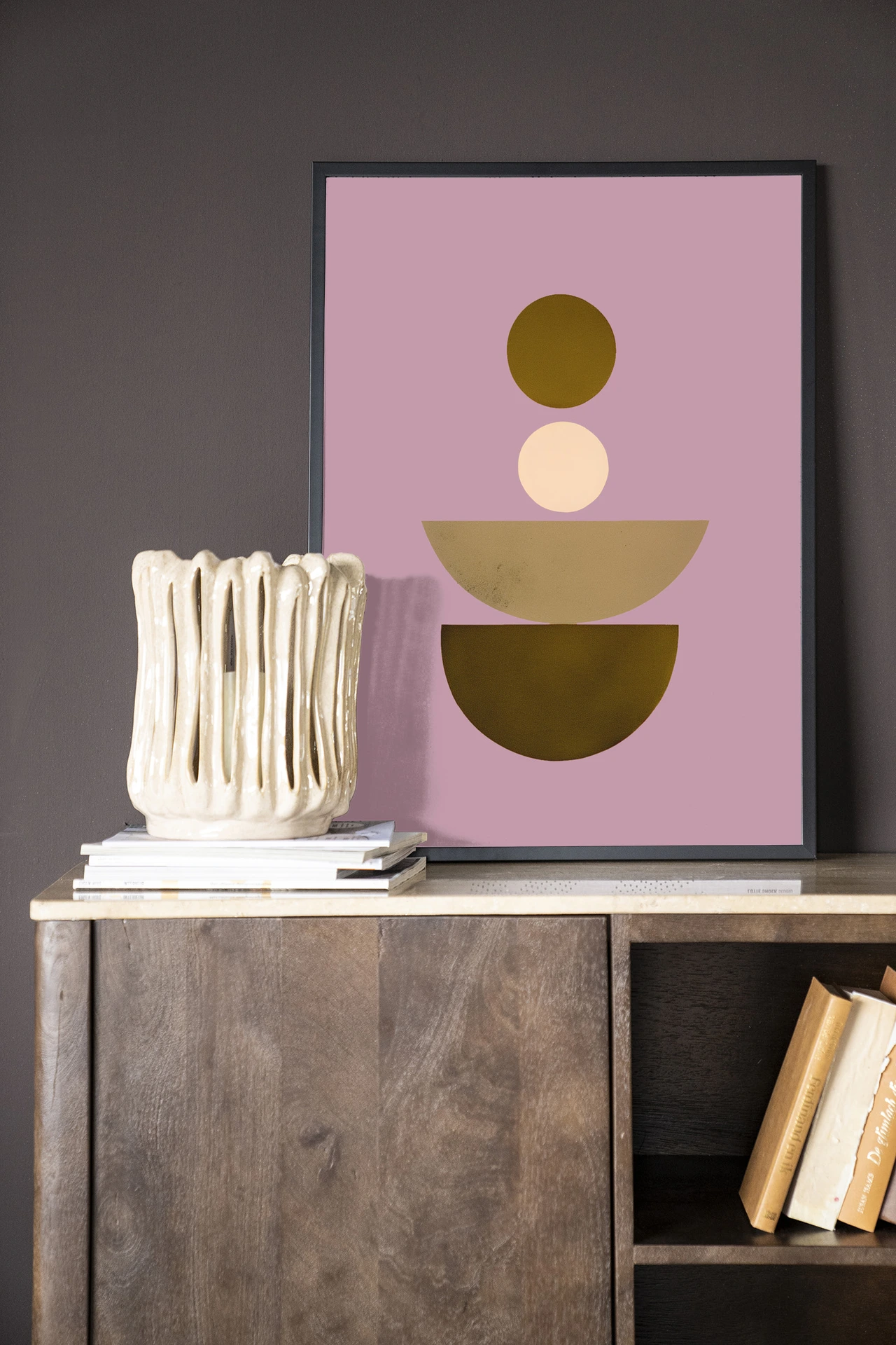 Wandkleed Forma 1 Lilac - Urban Cotton hangt aan een donkere muur boven een houten dressoir met decoratie