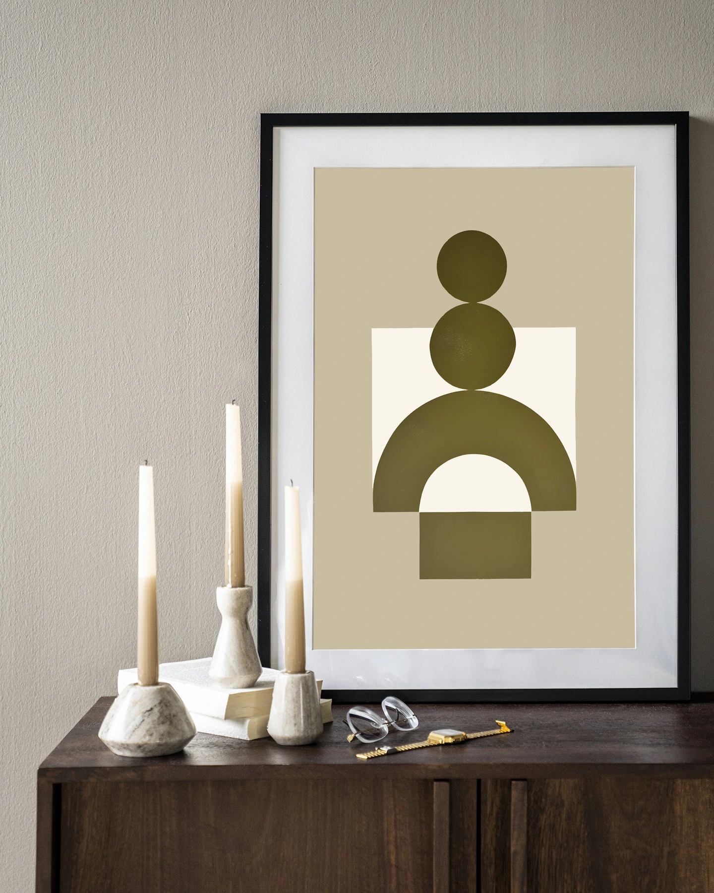 Wandkleed Forma 3 Beige - Urban Cotton in een lijst, staand op een donkerhouten dressoir met kaarsen en boeken