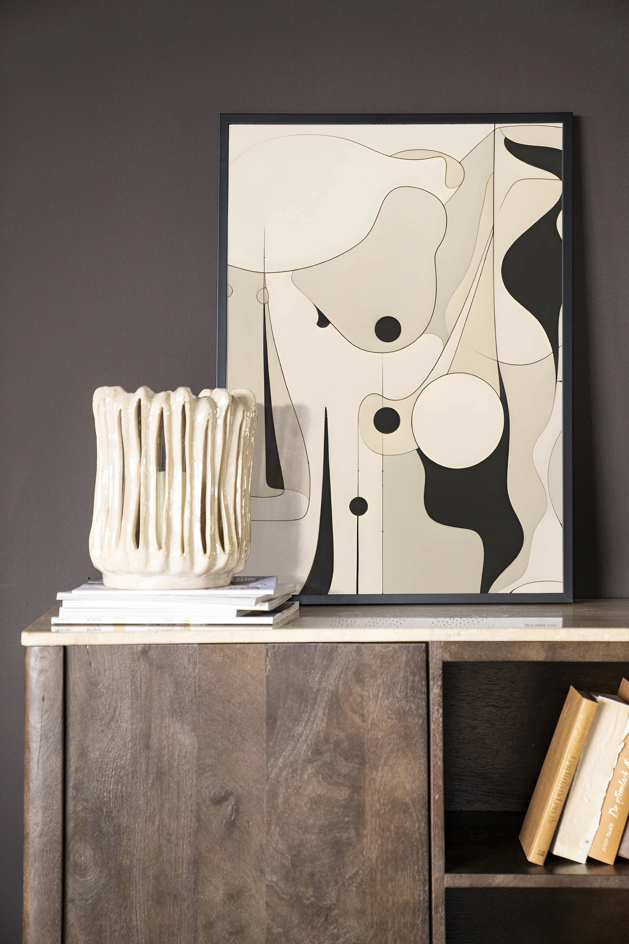 De Art print Rocamadour - Urban Cotton staat op een houten dressoir met een vaas en boeken