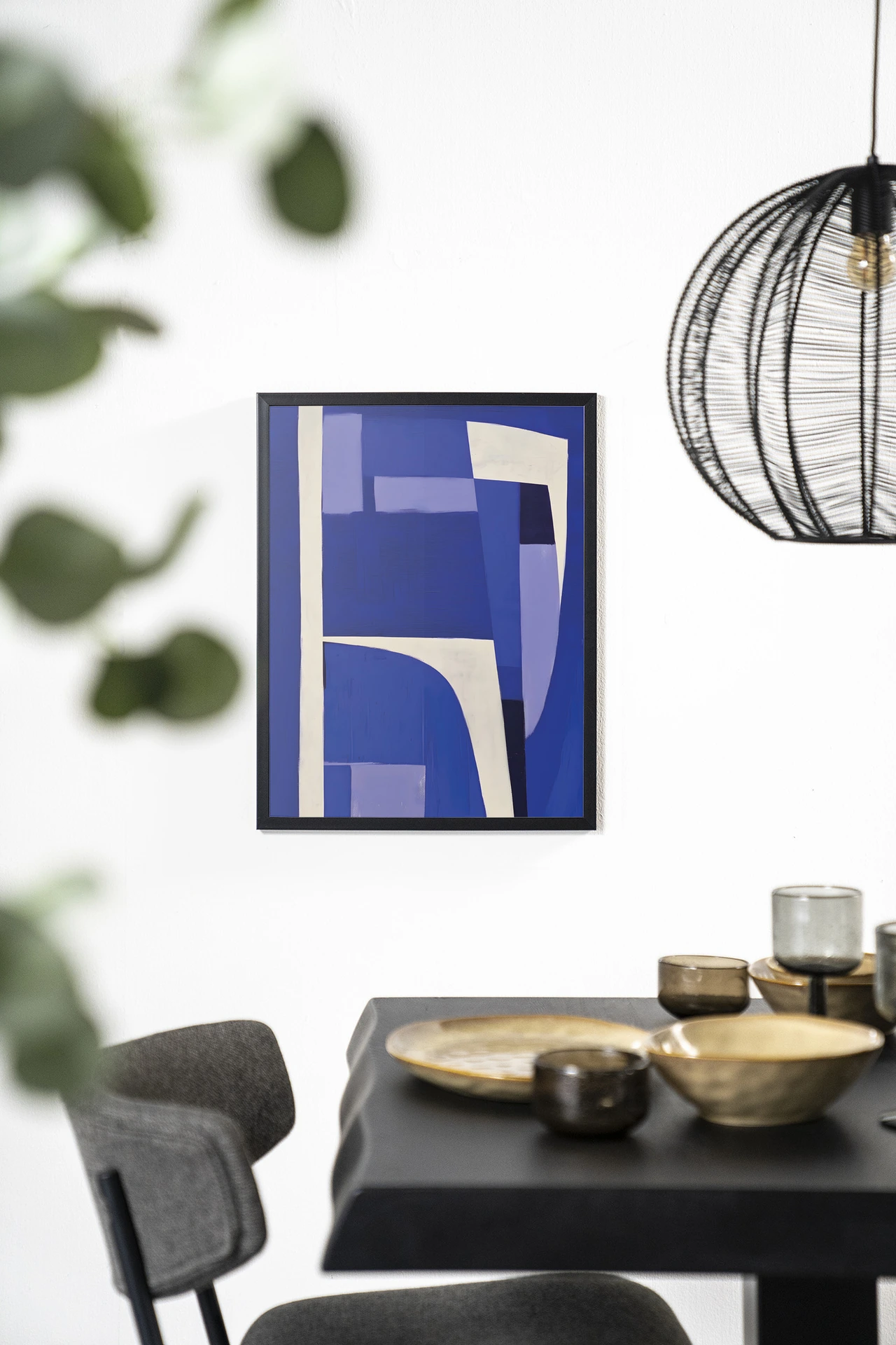 Art print Blues 1.0 - Urban Cotton hangend aan een witte muur boven een zwarte tafel