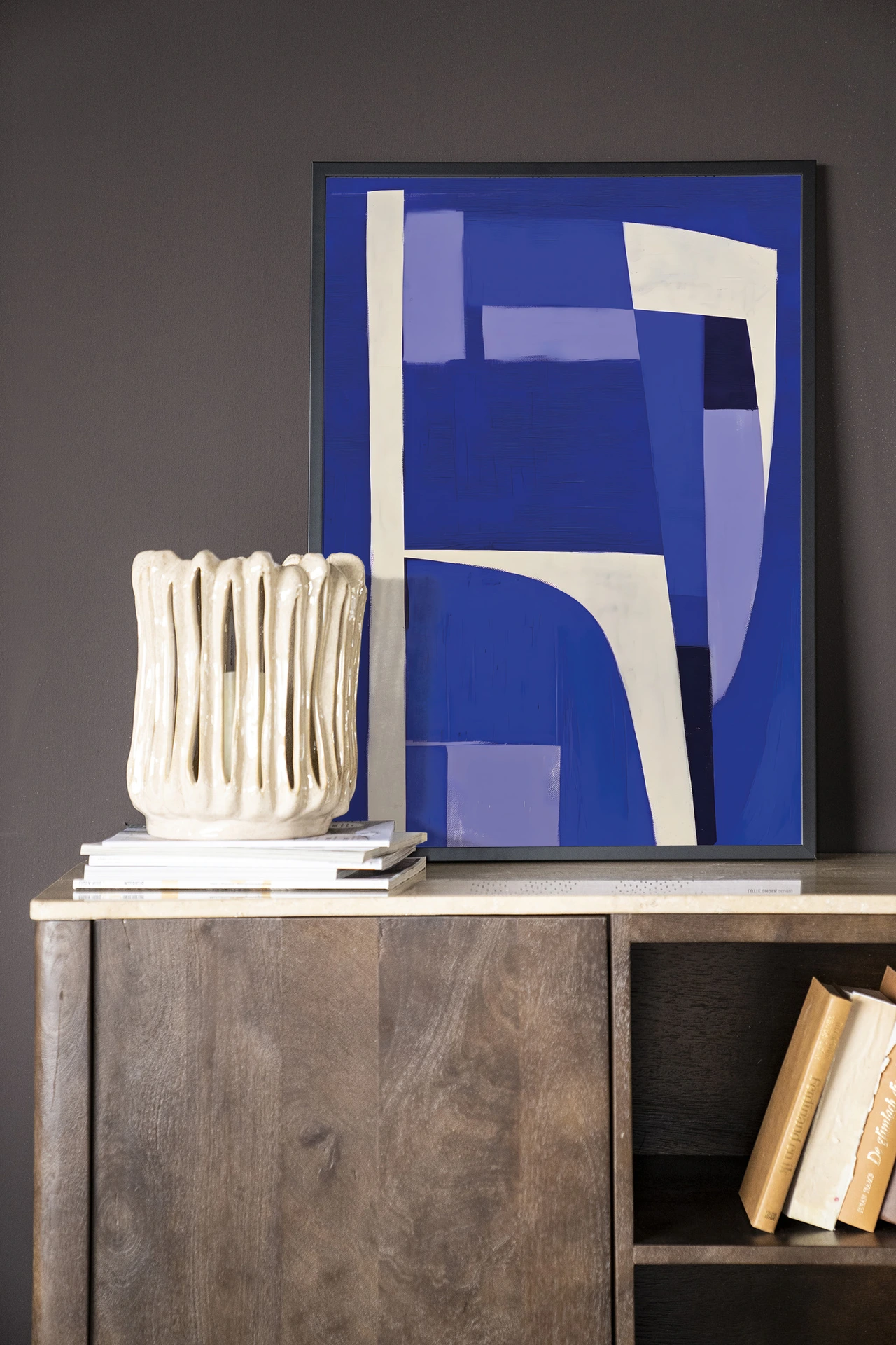 Art print Blues 1.0 - Urban Cotton in een zwarte lijst, leunend op een houten dressoir