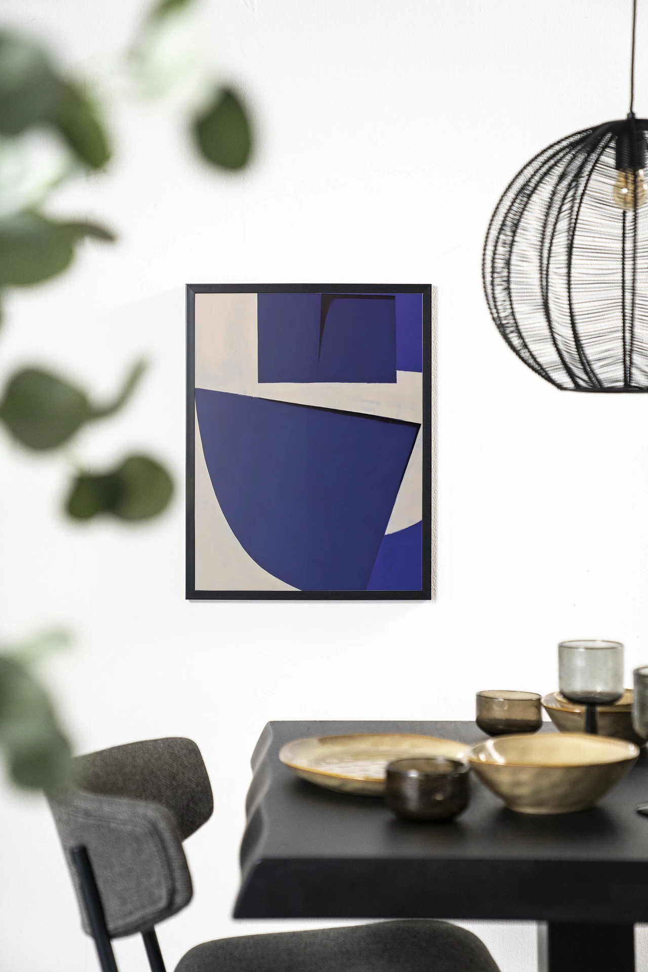 Art print Blues 3.0 - Urban Cotton hangt aan een witte muur boven een zwarte tafel met gouden schalen