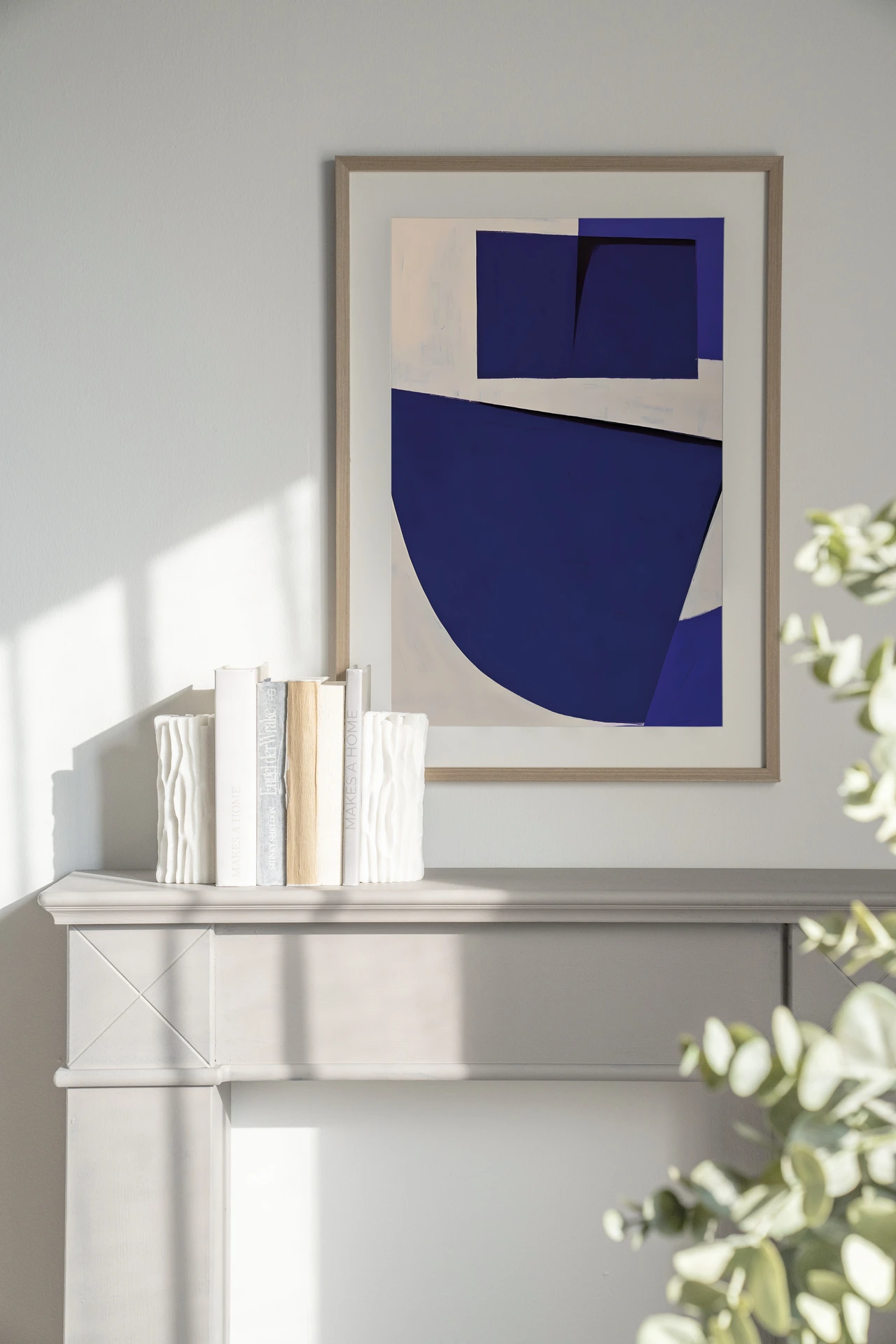 Art print Blues 3.0 - Urban Cotton hangend boven een lichte schouw met boeken en vazen