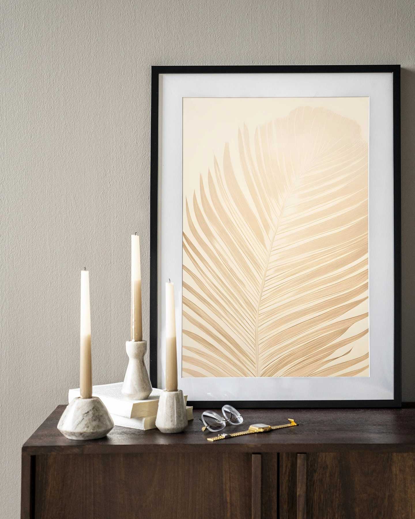 Wandkleed Feuille - Urban Cotton hangend boven een donkerbruin dressoir met kaarsen en boeken