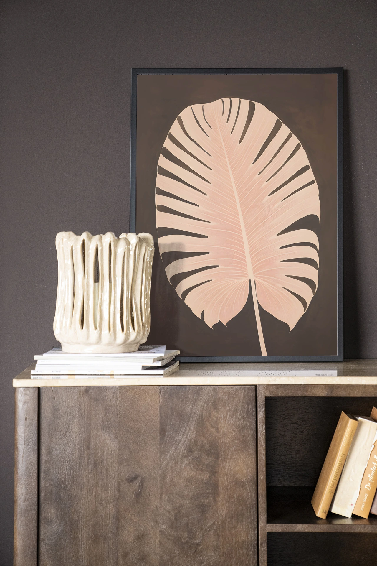 Art print Pink Leaf - Urban Cotton in een donkere setting met een beige vaas en boeken