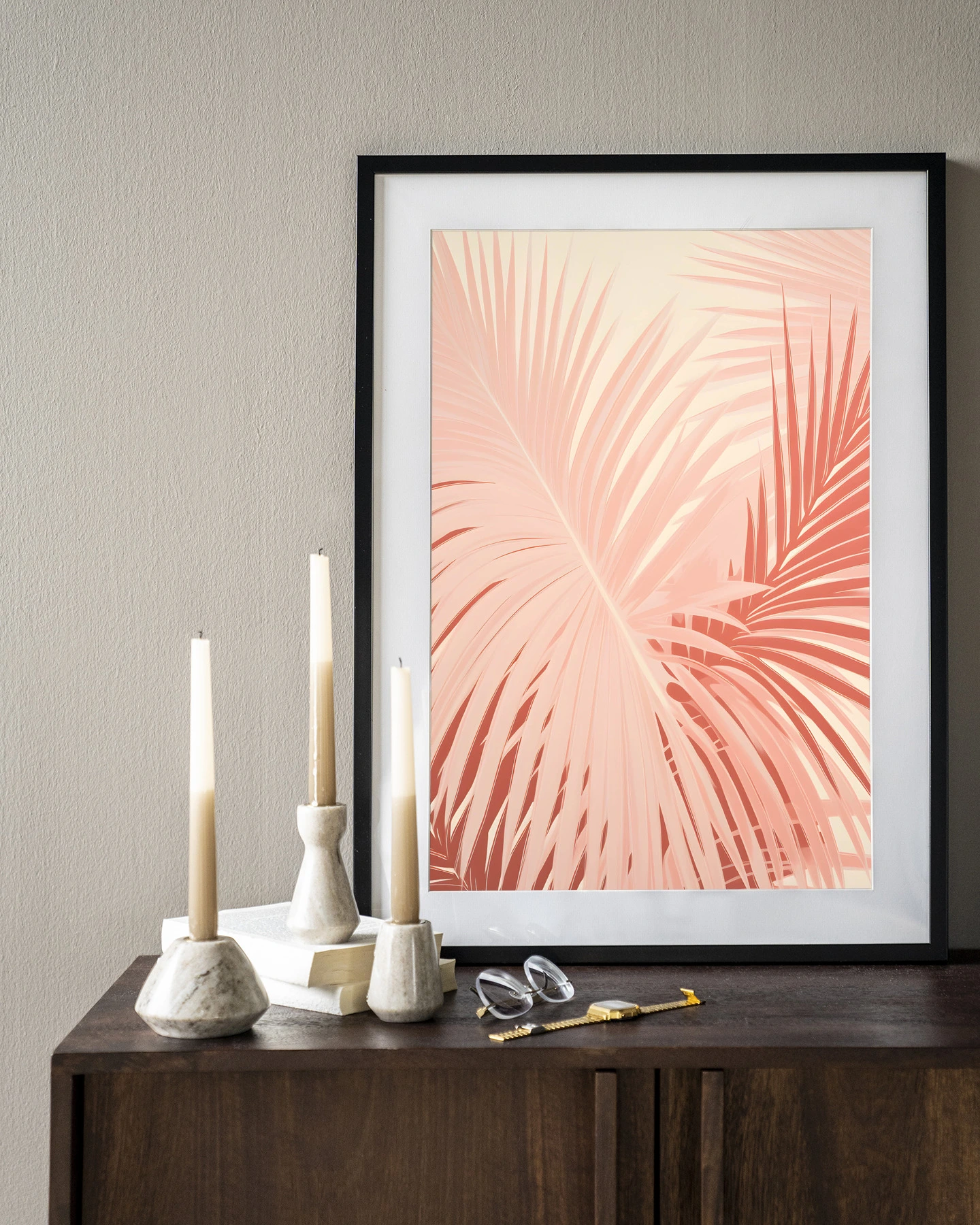 Art print Pink Palm - Urban Cotton in een zwarte lijst op een donkerbruin dressoir met kaarsen en boeken