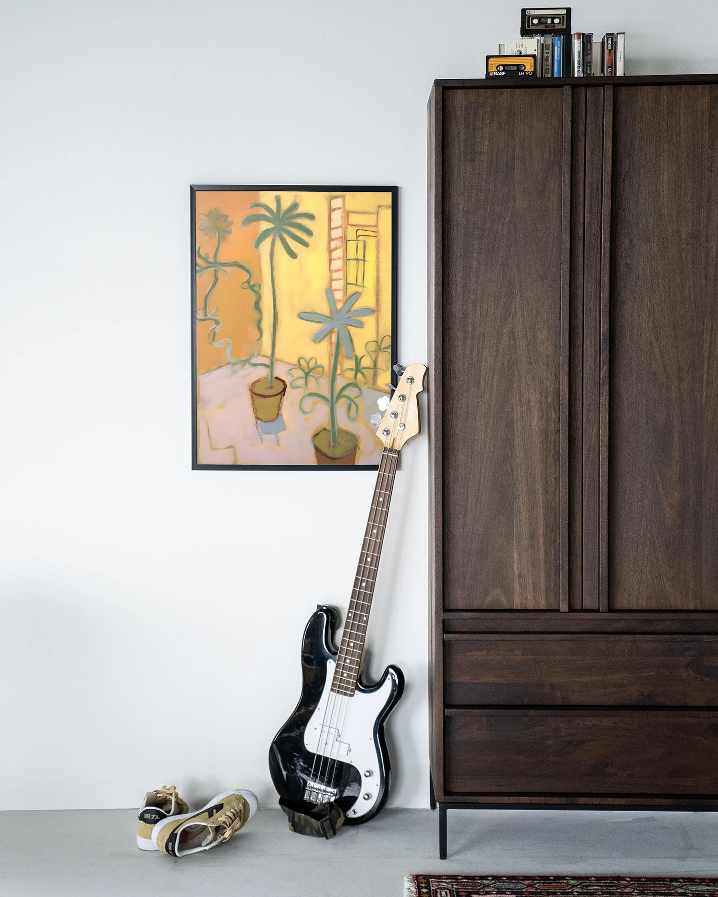 Wandkleed Cabo Verde - Urban Cotton hangend aan een witte muur naast een donkerhouten kast