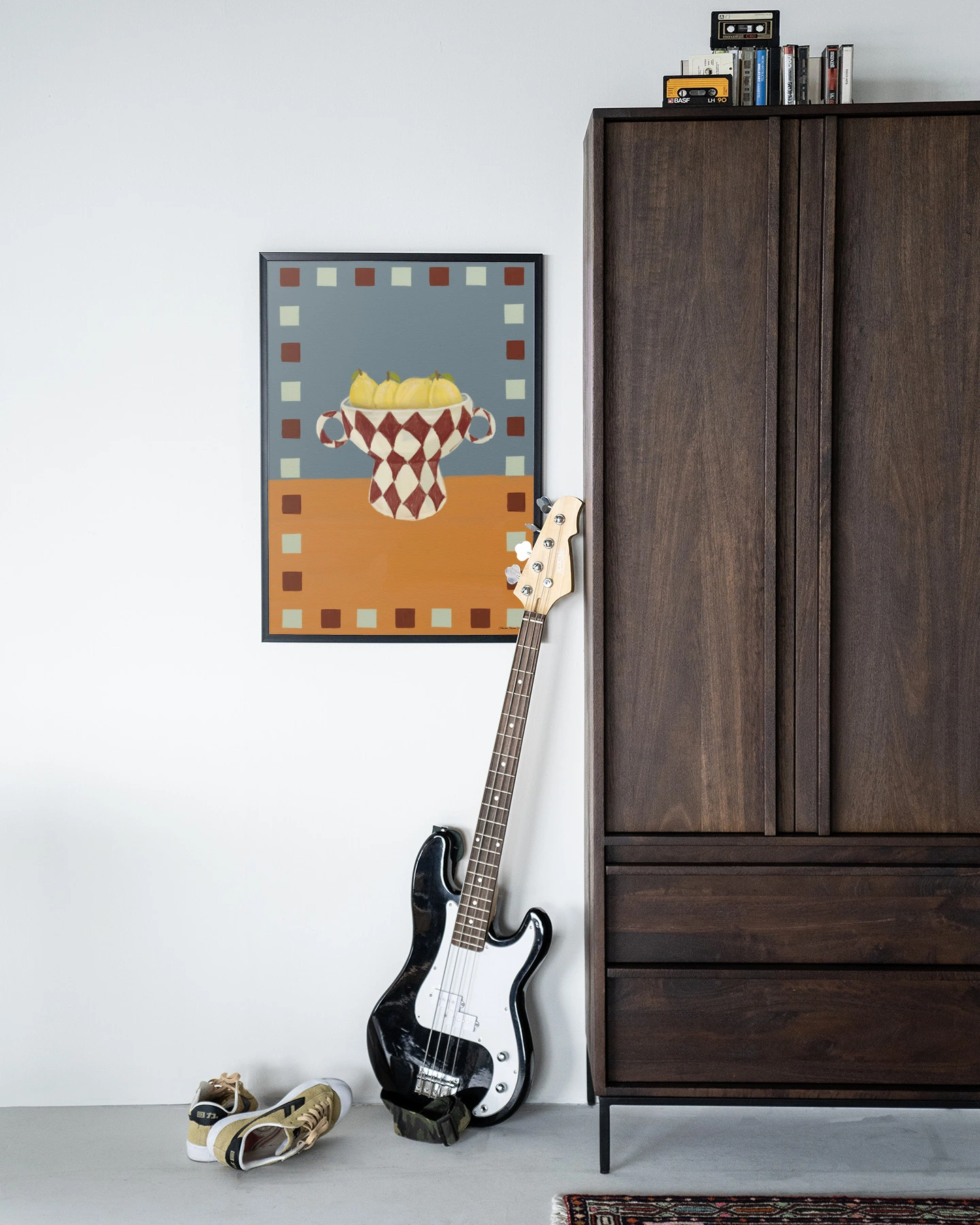 Wandkleed Eclectic Series 4 - Urban Cotton hangend aan een witte muur naast een donkerbruine kast met een basgitaar ervoor
