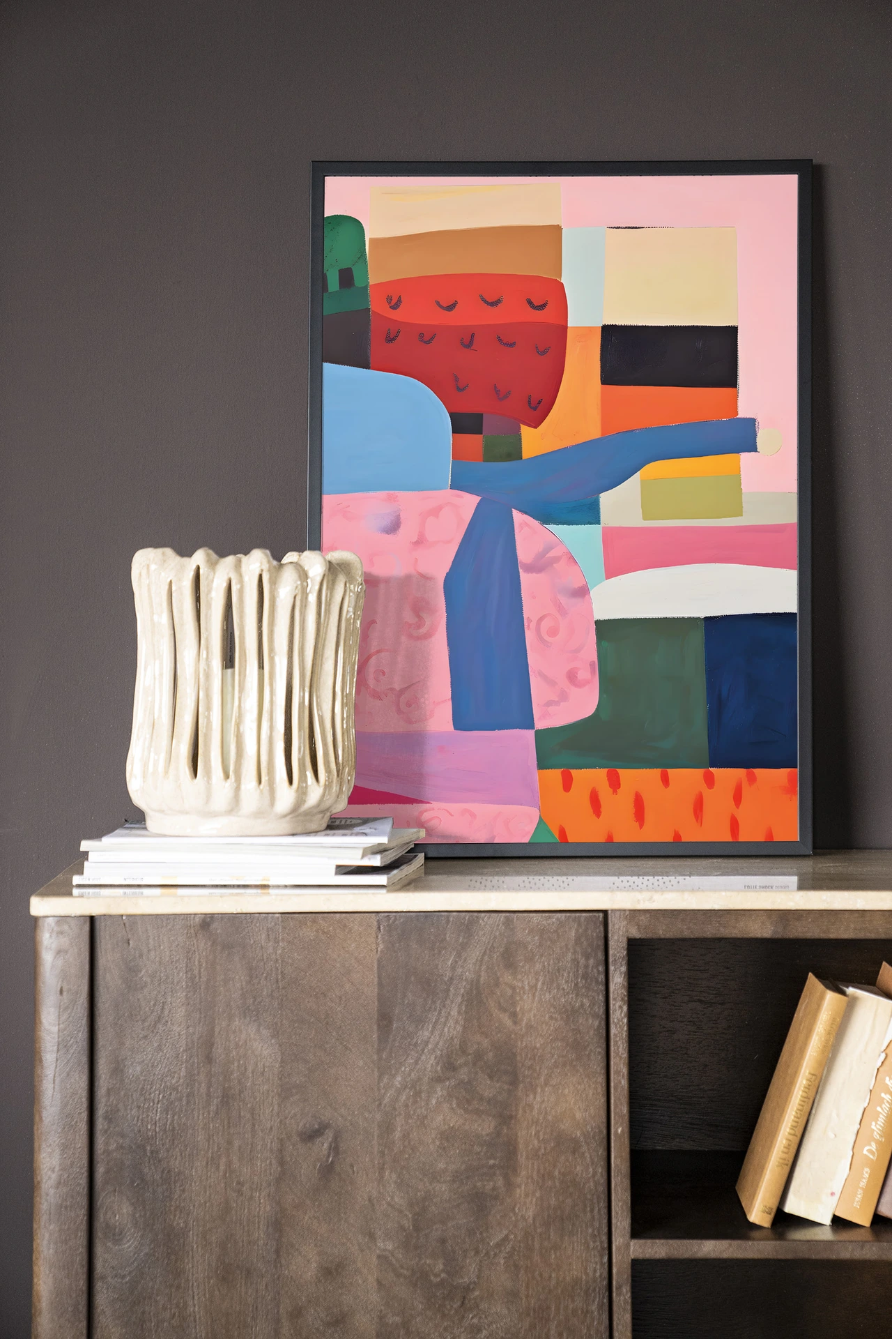 Wandkleed Colour Stacking - Urban Cotton op een houten dressoir met boeken en een witte vaas
