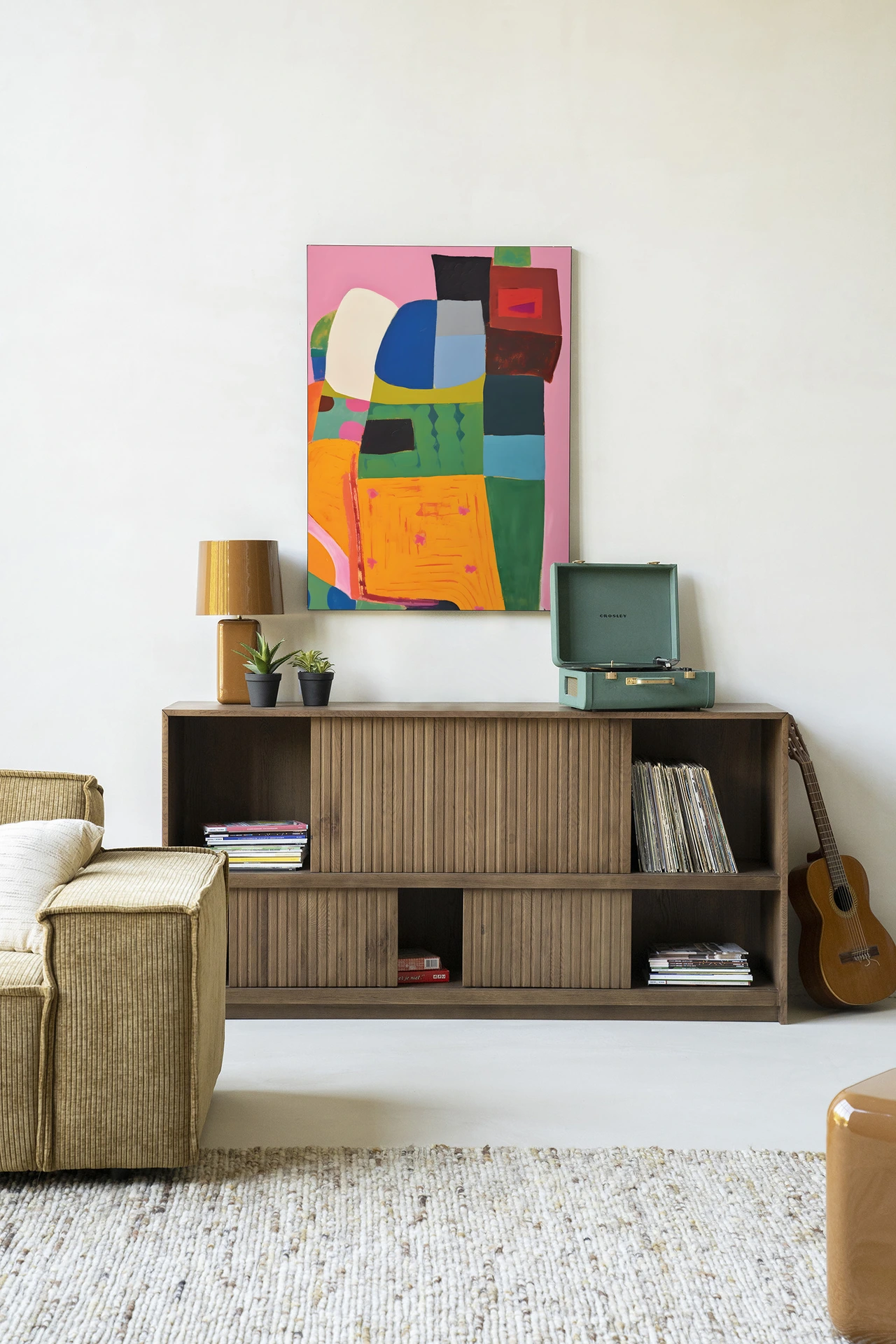Wandkleed Fields of Colour - Urban Cotton hangt boven een houten dressoir met een platenspeler en gitaar in een woonkamer