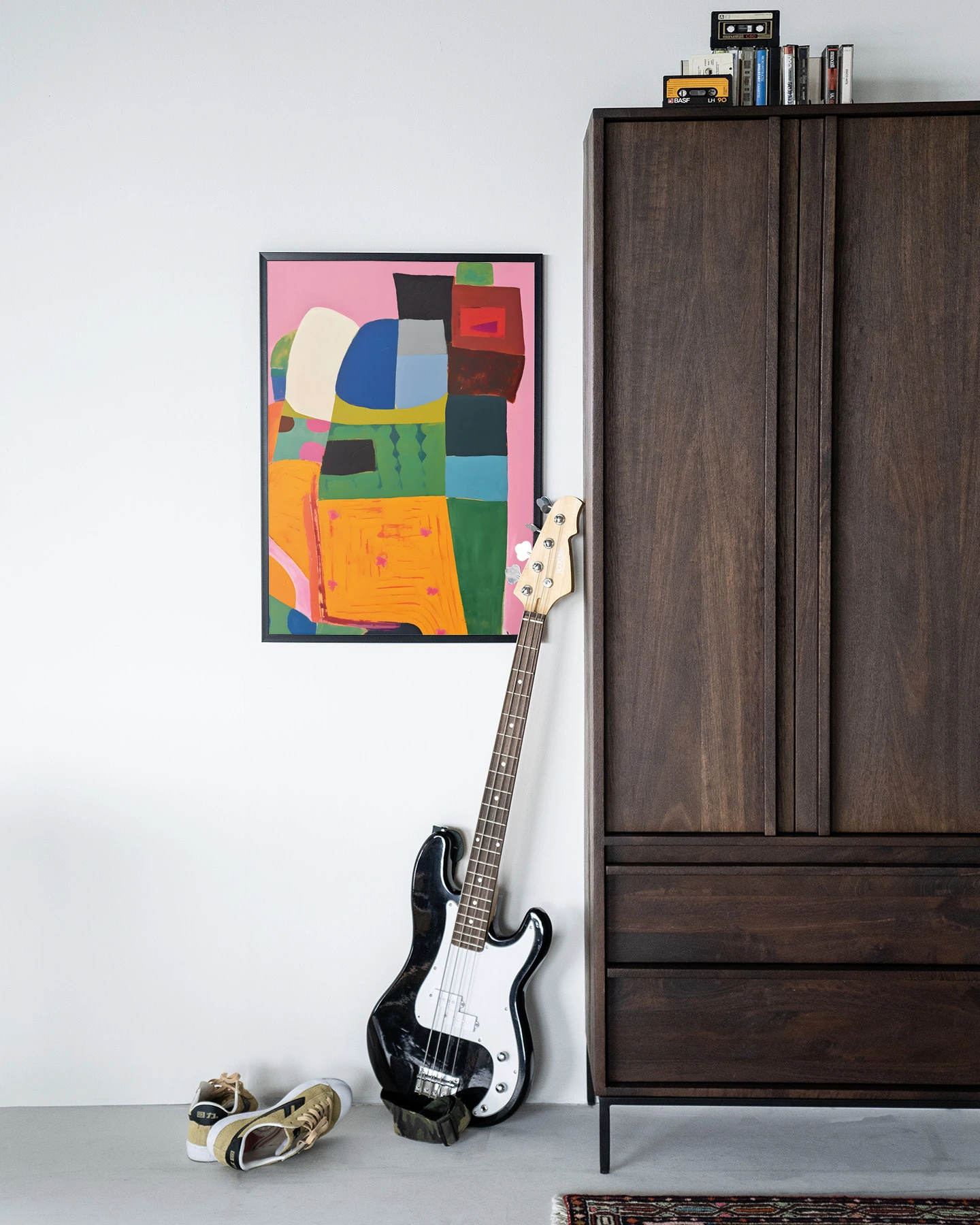 Wandkleed Fields of Colour - Urban Cotton hangend aan een witte muur, met een basgitaar en schoenen ervoor