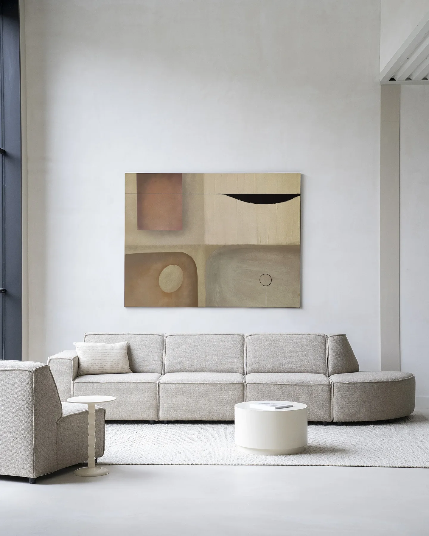 Wandkleed Define - Urban Cotton hangend boven een beige modulaire bank in een moderne woonkamer