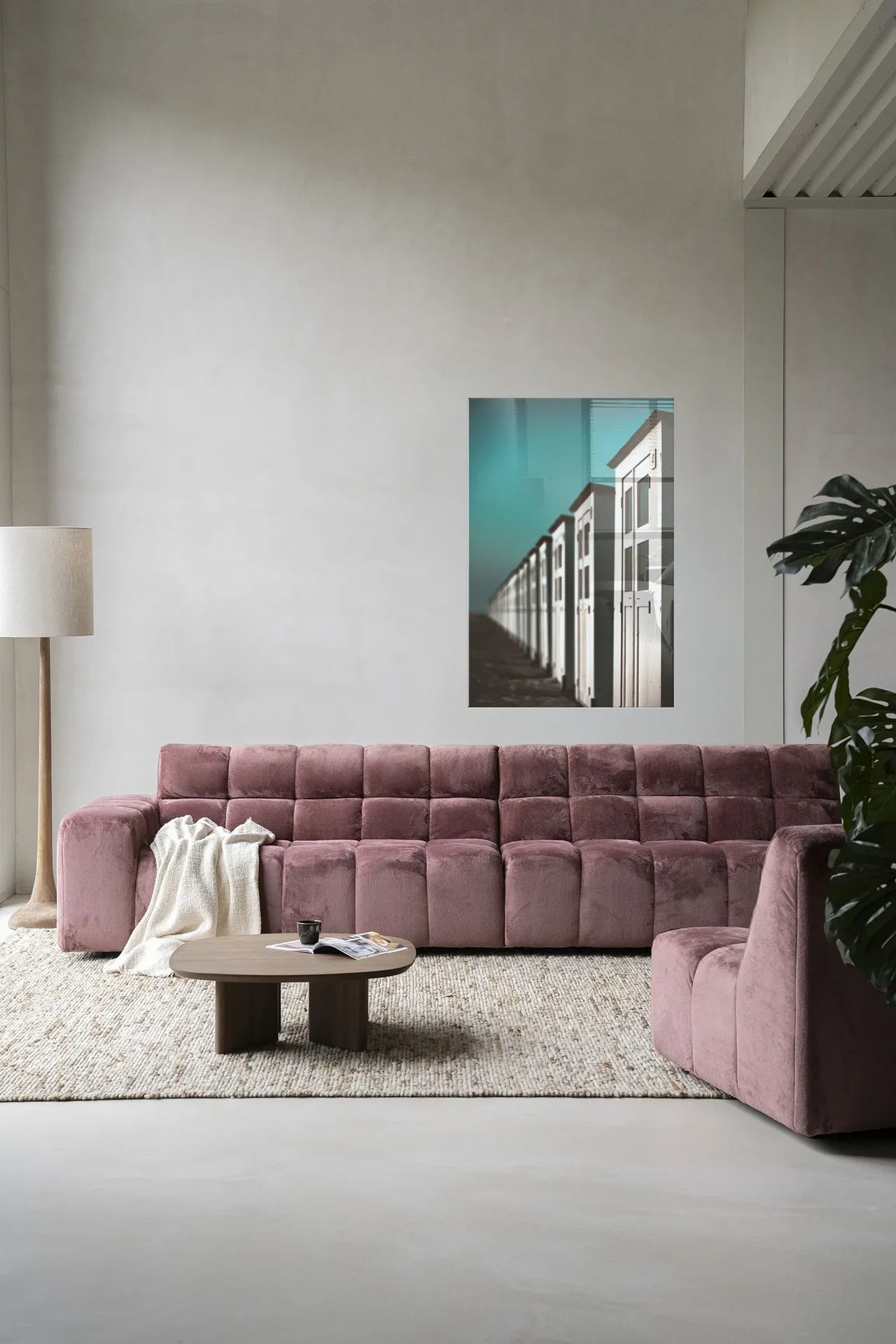 Wandkleed City Life @ The Beach - Urban Cotton hangend boven een roze bank in een moderne woonkamer
