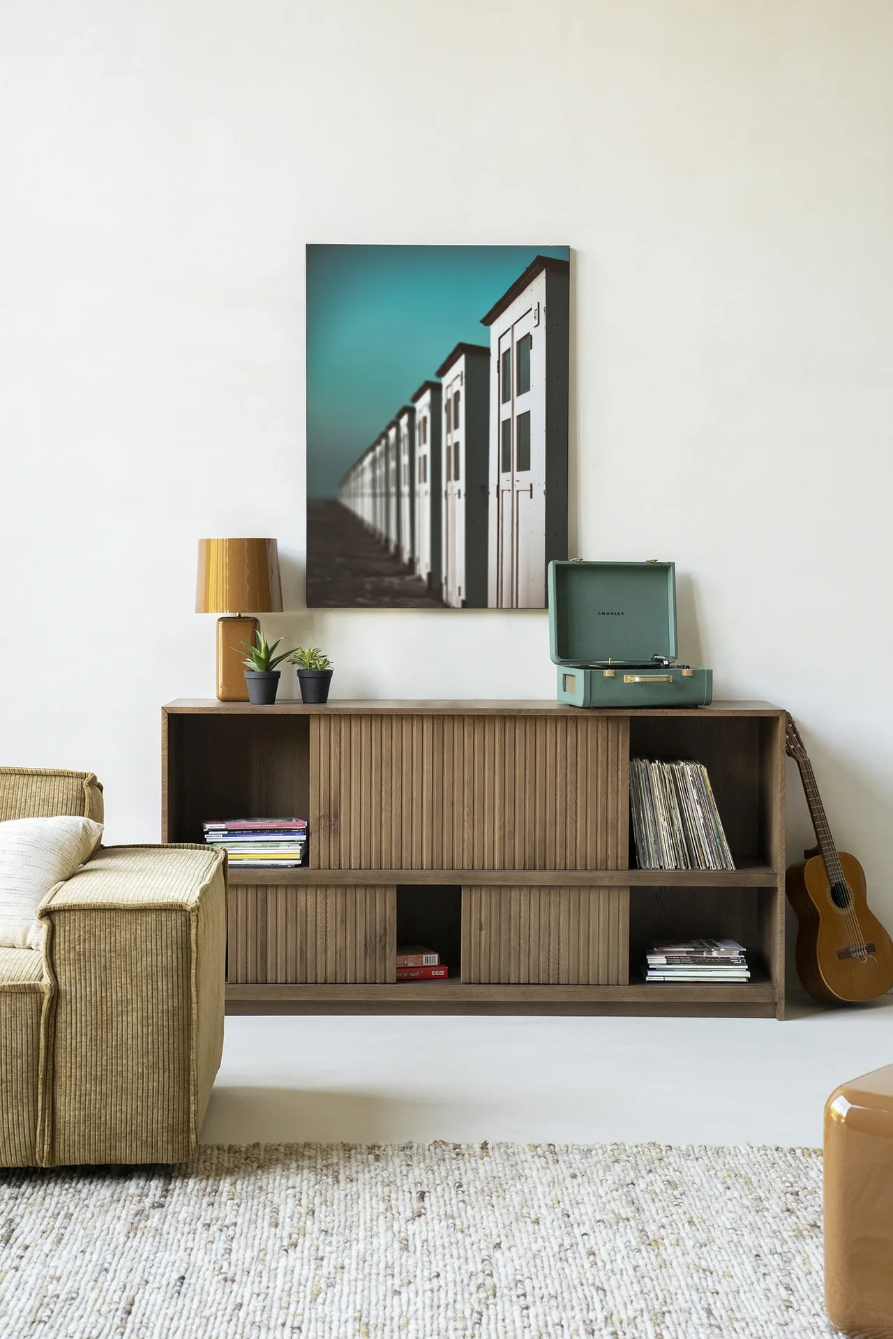 Wandkleed City Life @ The Beach - Urban Cotton hangend boven een houten dressoir in een lichte woonkamer