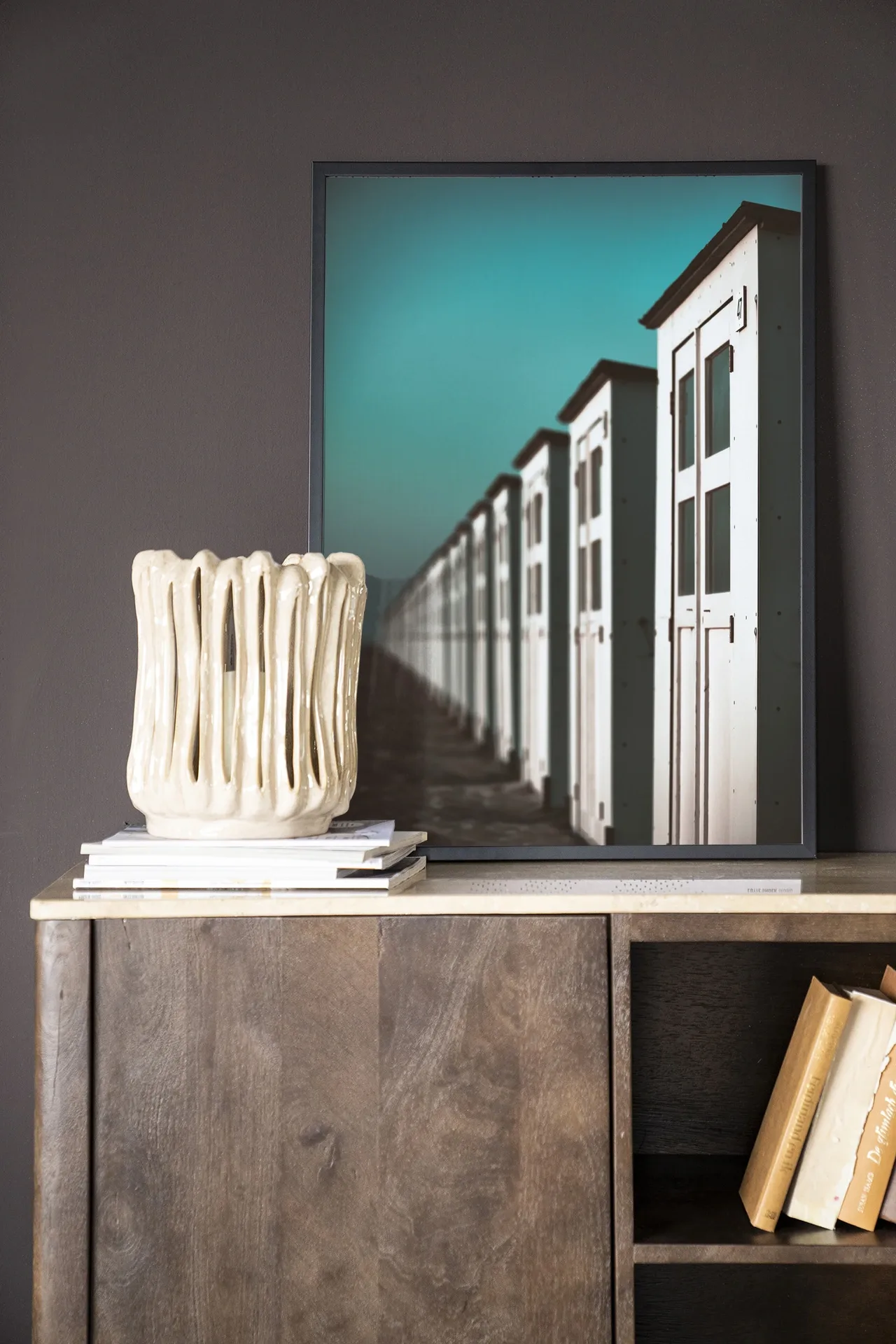 Wandkleed City Life @ The Beach - Urban Cotton hangt boven een houten dressoir met decoratie