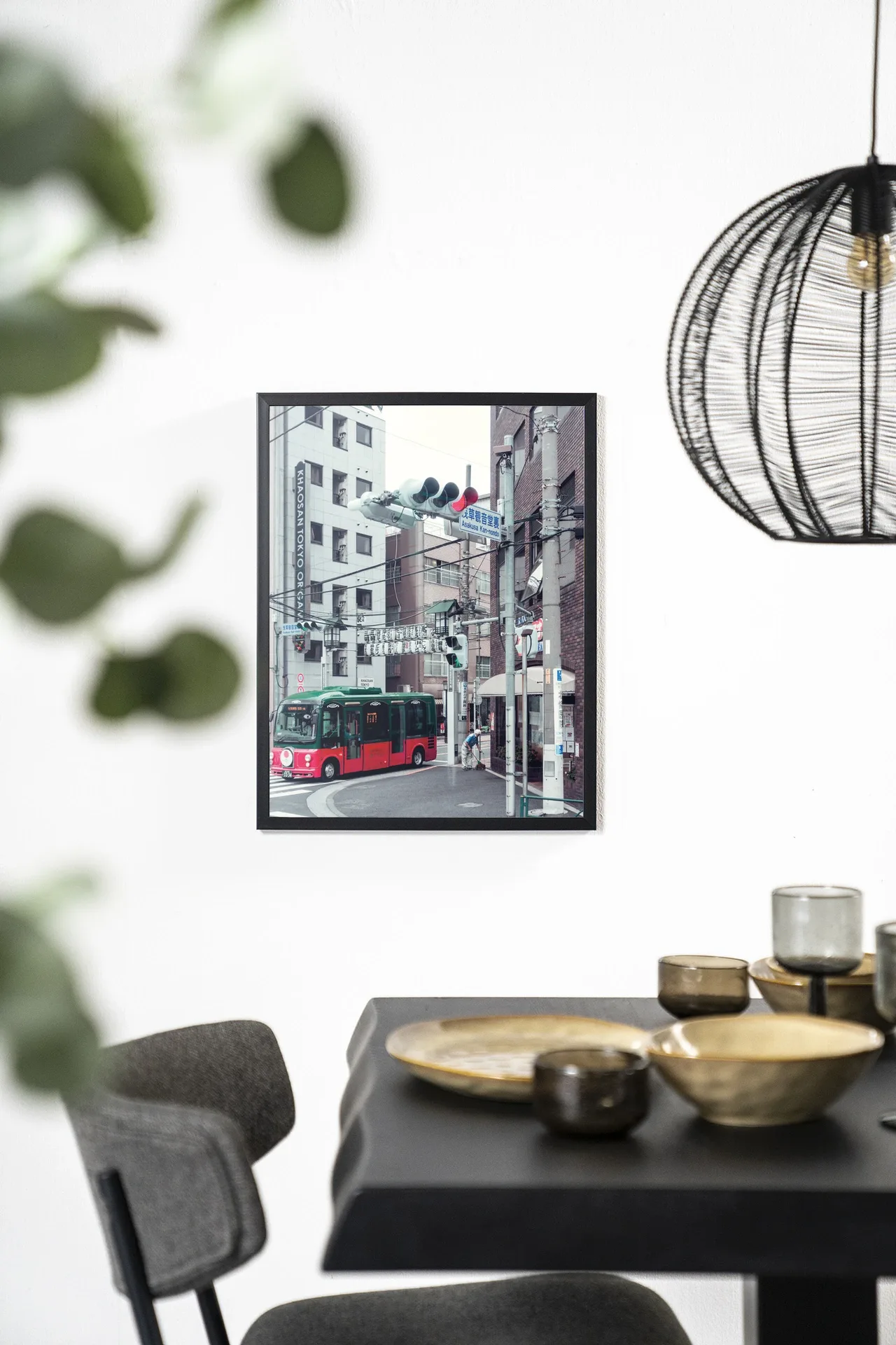 Wandkleed Complementary Bus - Urban Cotton hangt aan een witte muur boven een zwarte tafel