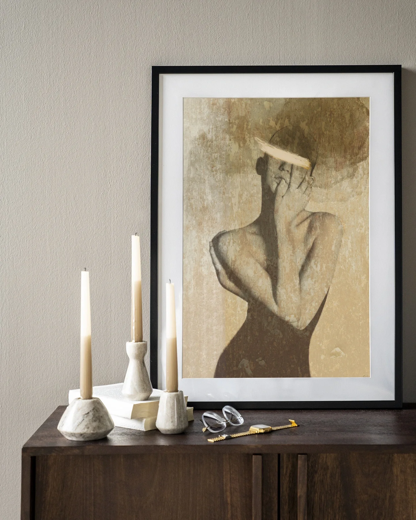 Wandkleed Self Love - Urban Cotton in een zwarte lijst, staand op een houten dressoir met kaarsen en bril