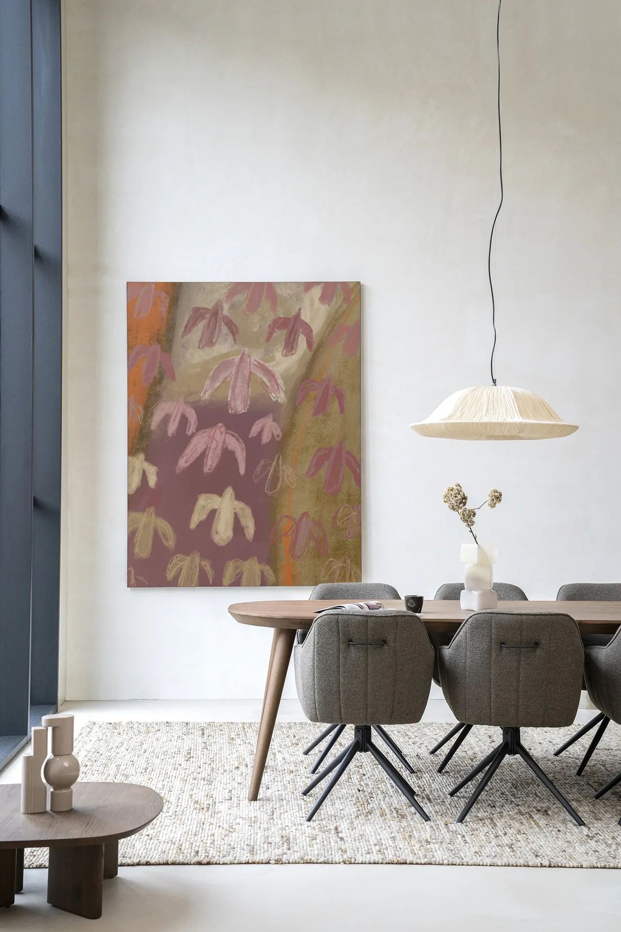 Wandkleed A Birds View van Urban Cotton hangt aan een witte muur boven een houten eettafel met grijze stoelen