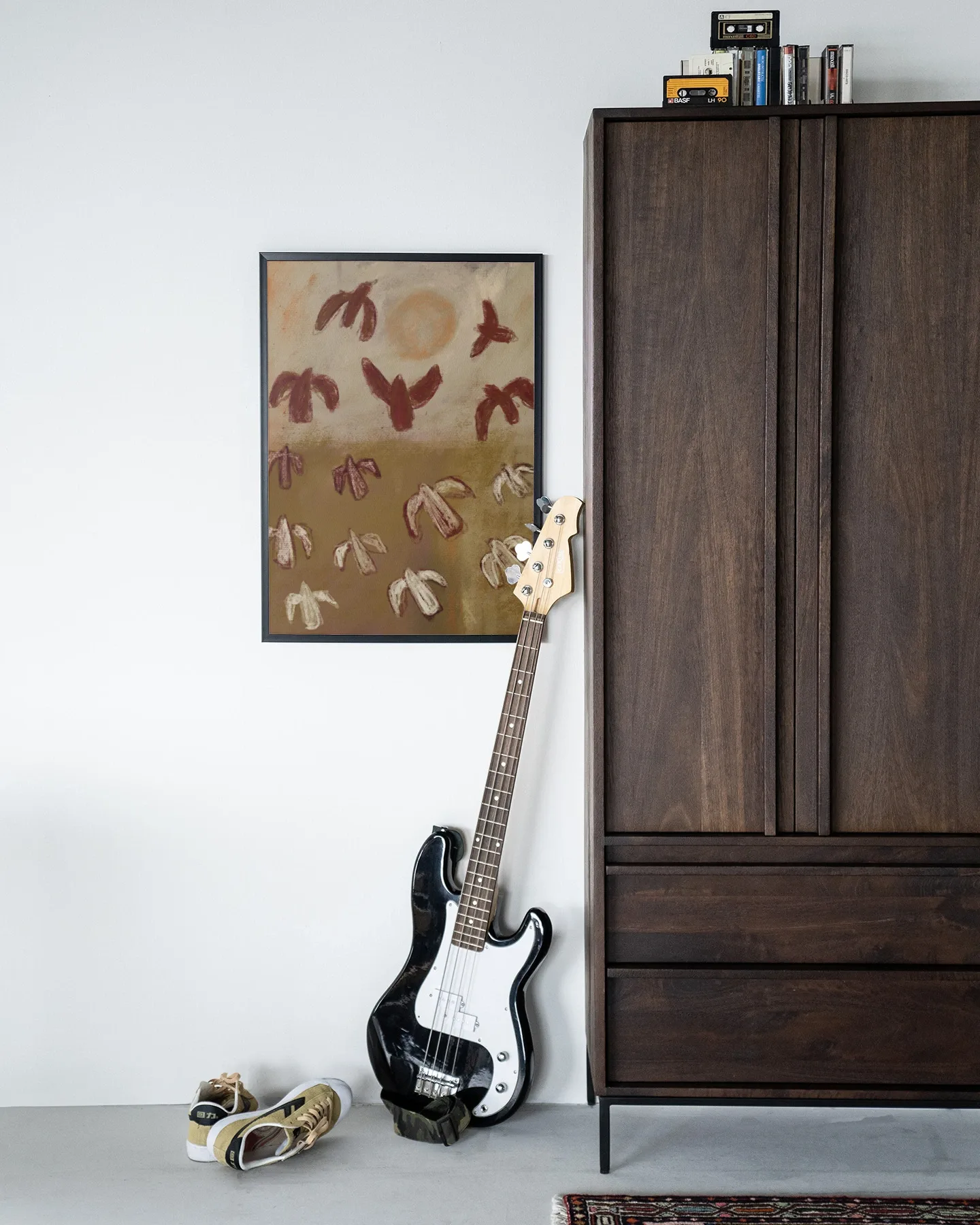 Het Wandkleed Sunbirds - Urban Cotton hangt aan een witte muur naast een donkerbruine kast