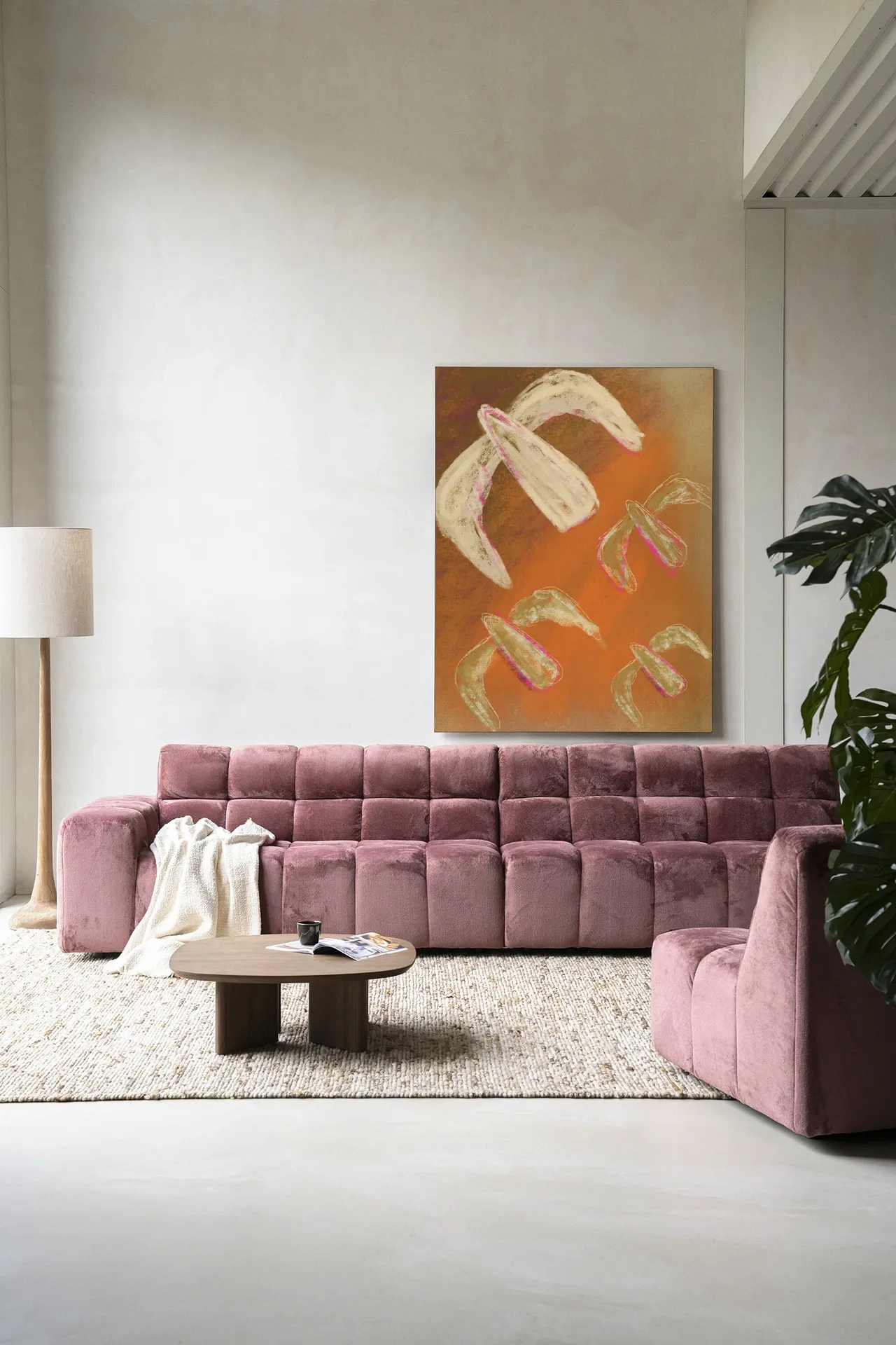 Wandkleed Bird Rise - Urban Cotton hangt boven een roze bank in een moderne woonkamer