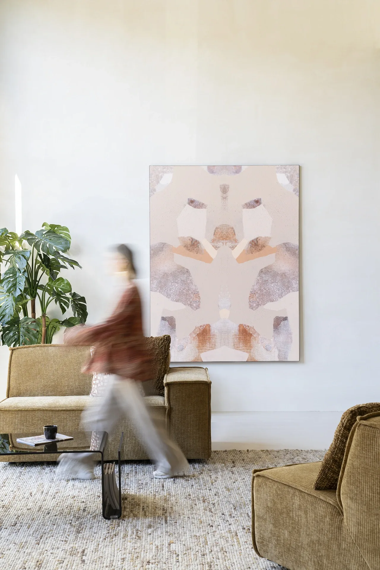 Wandkleed Sand Fox - Urban Cotton in een lichte woonkamer met een persoon in beweging