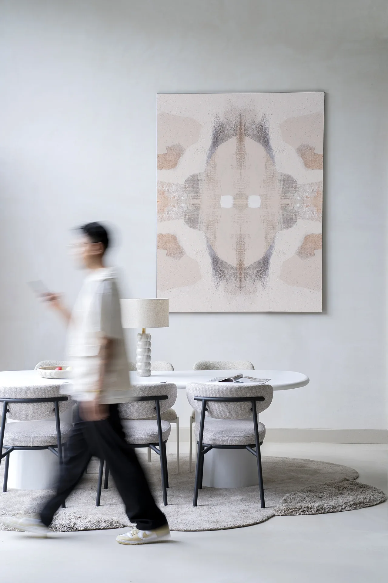 Wandkleed Chiru Antelope hangt boven een eettafel met stoelen, een lamp en een persoon die voorbijloopt - Urban Cotton