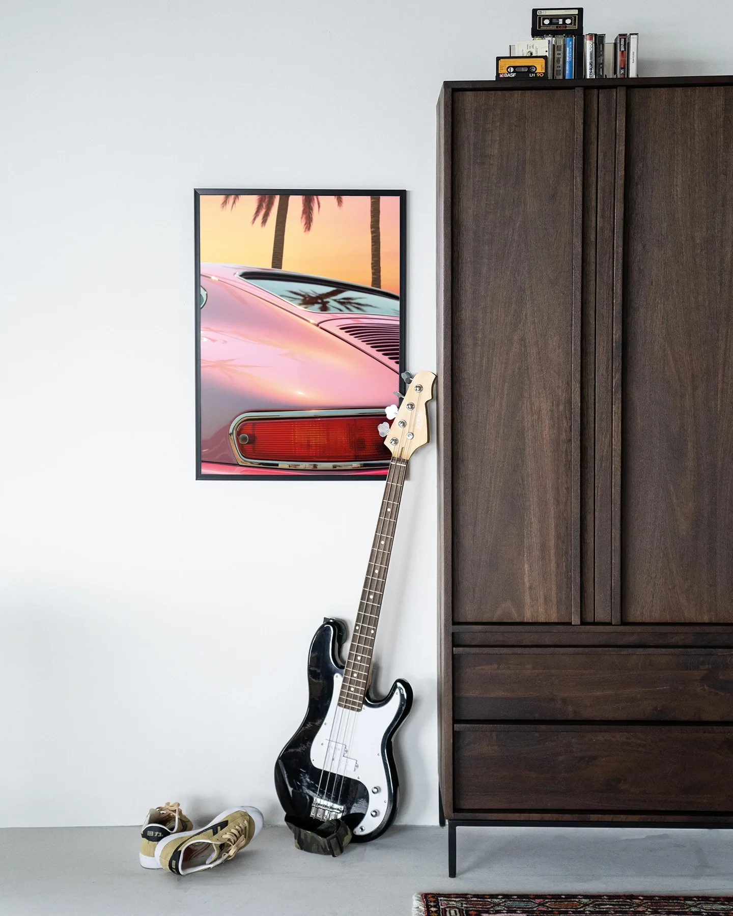 Wandkleed Miami Vice - Urban Cotton hangend aan een witte muur, met basgitaar en schoenen ervoor