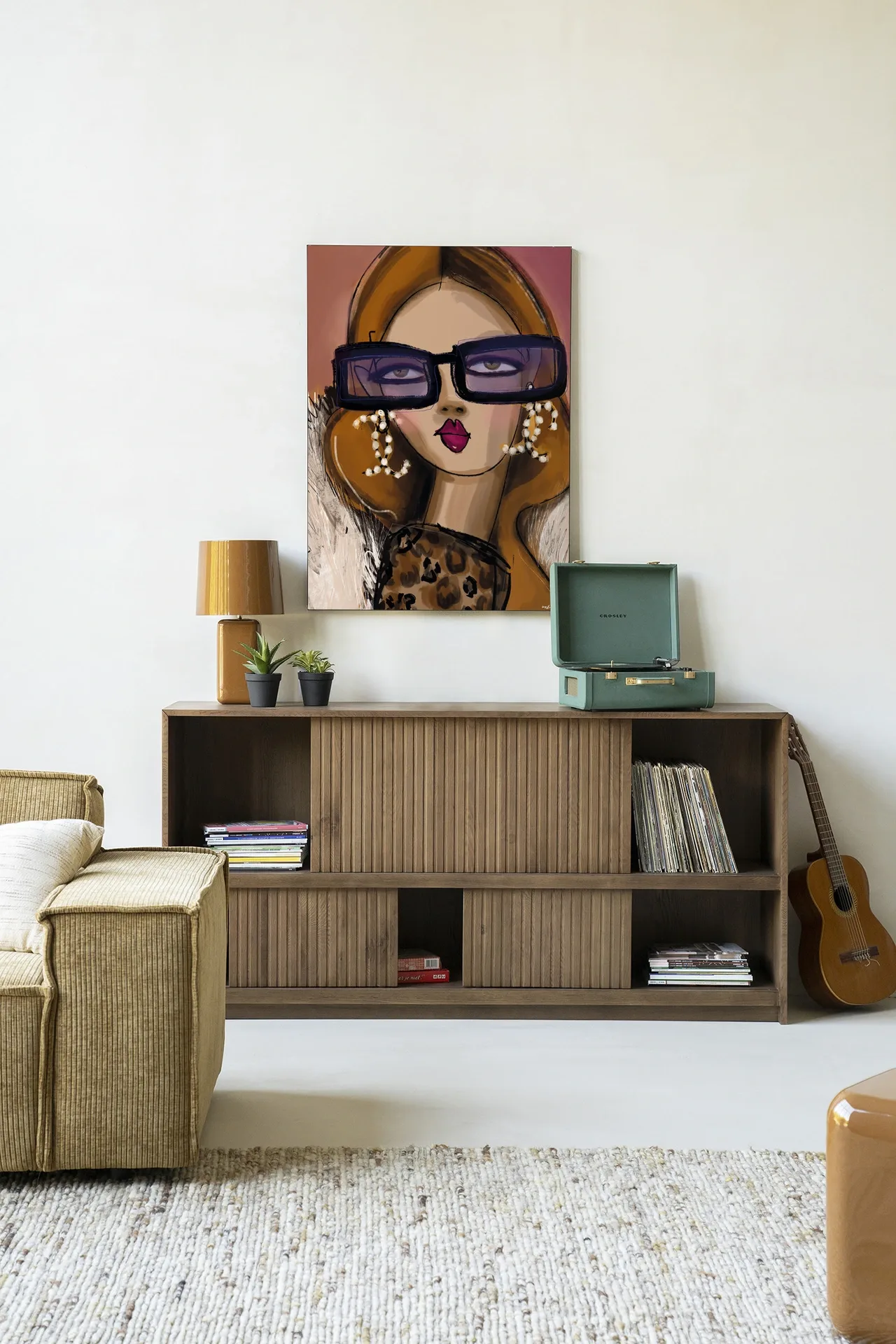Wandkleed Diva - Urban Cotton hangt boven een houten dressoir met decoratie in een lichte woonkamer