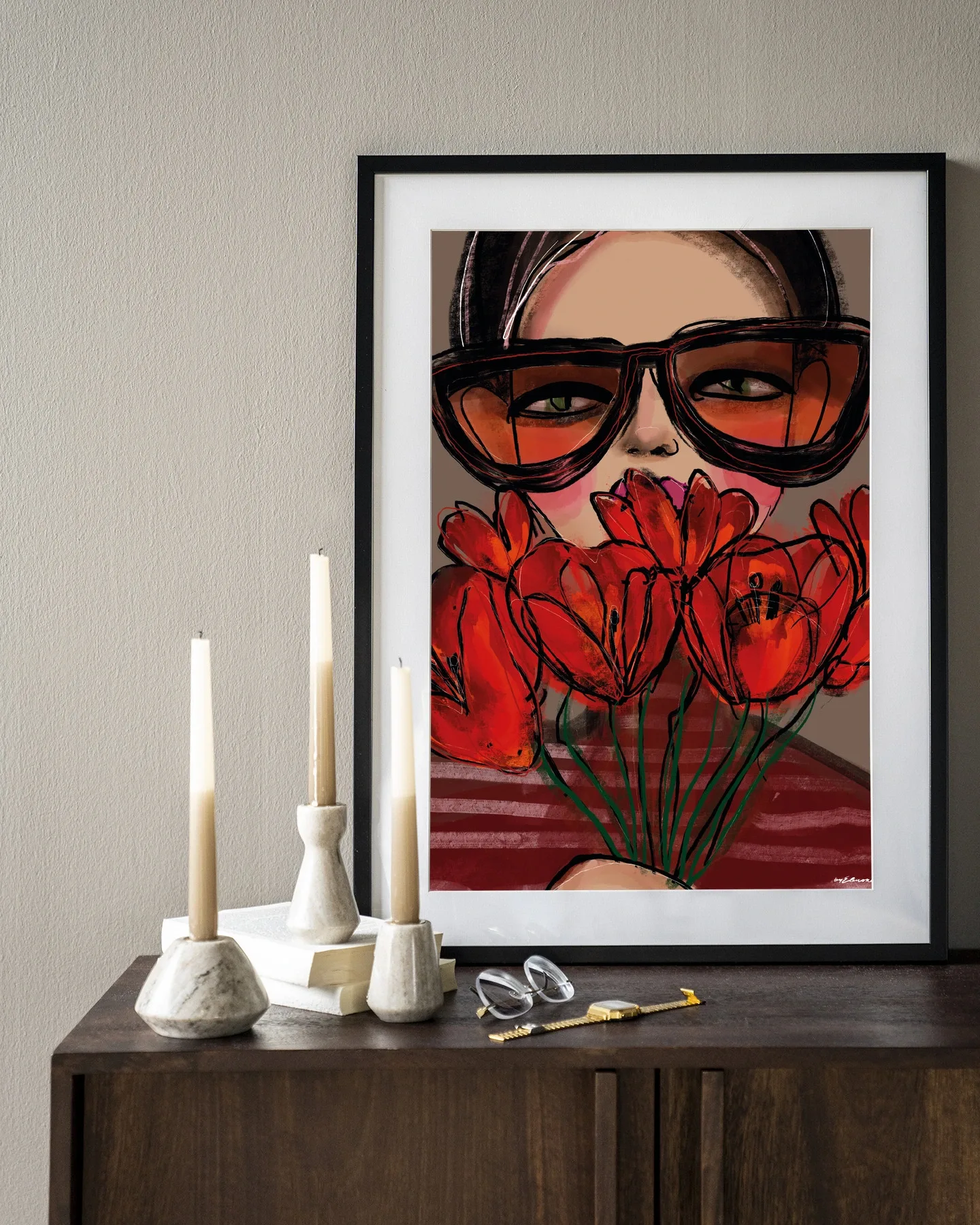Wandkleed Poppy - Urban Cotton in een zwarte lijst, hangend boven een houten dressoir met kaarsen