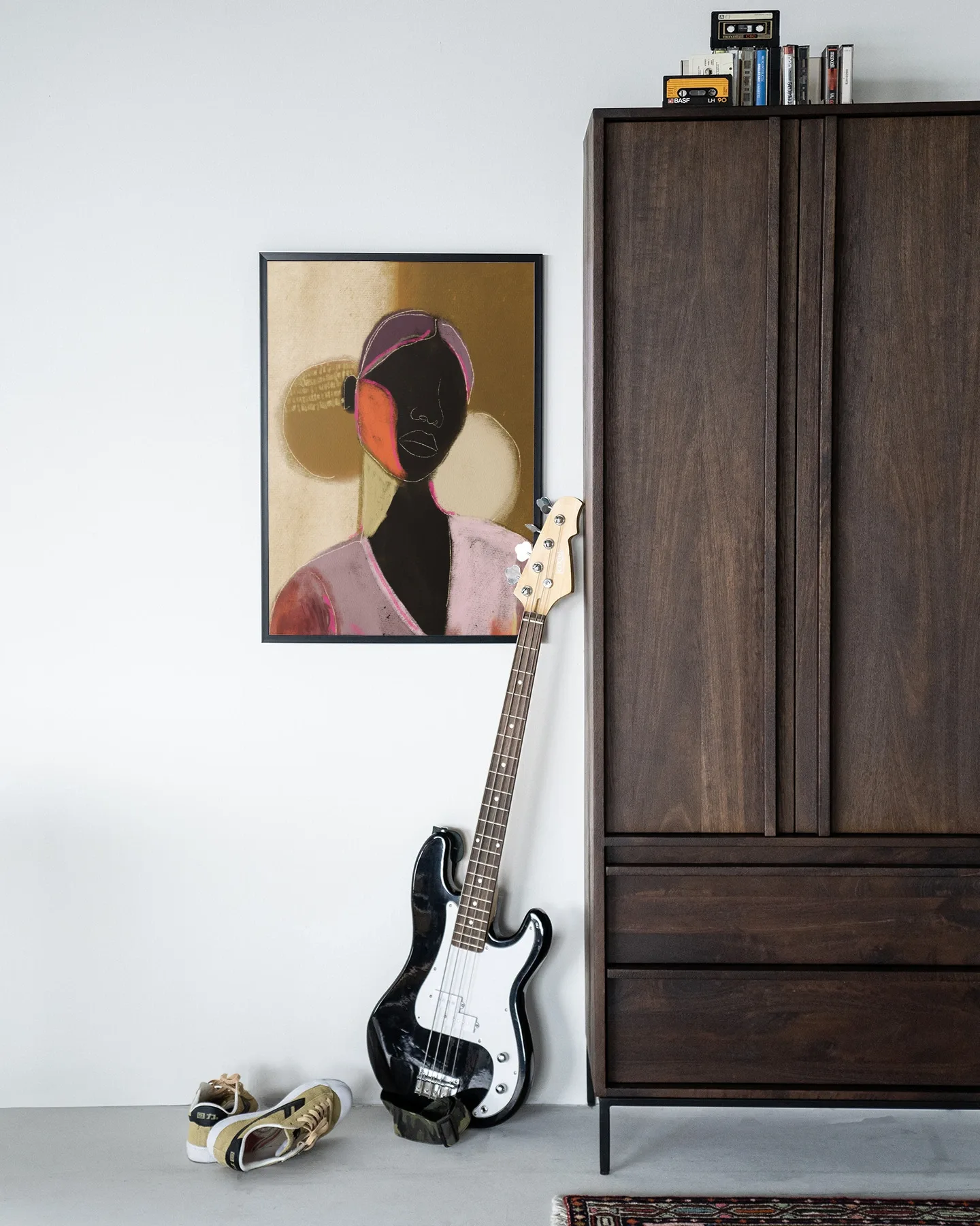 Wandteppich Silhouette Lady 1 - Urban Cotton hängt an einer weißen Wand, mit einer Bassgitarre und Schuhen daneben