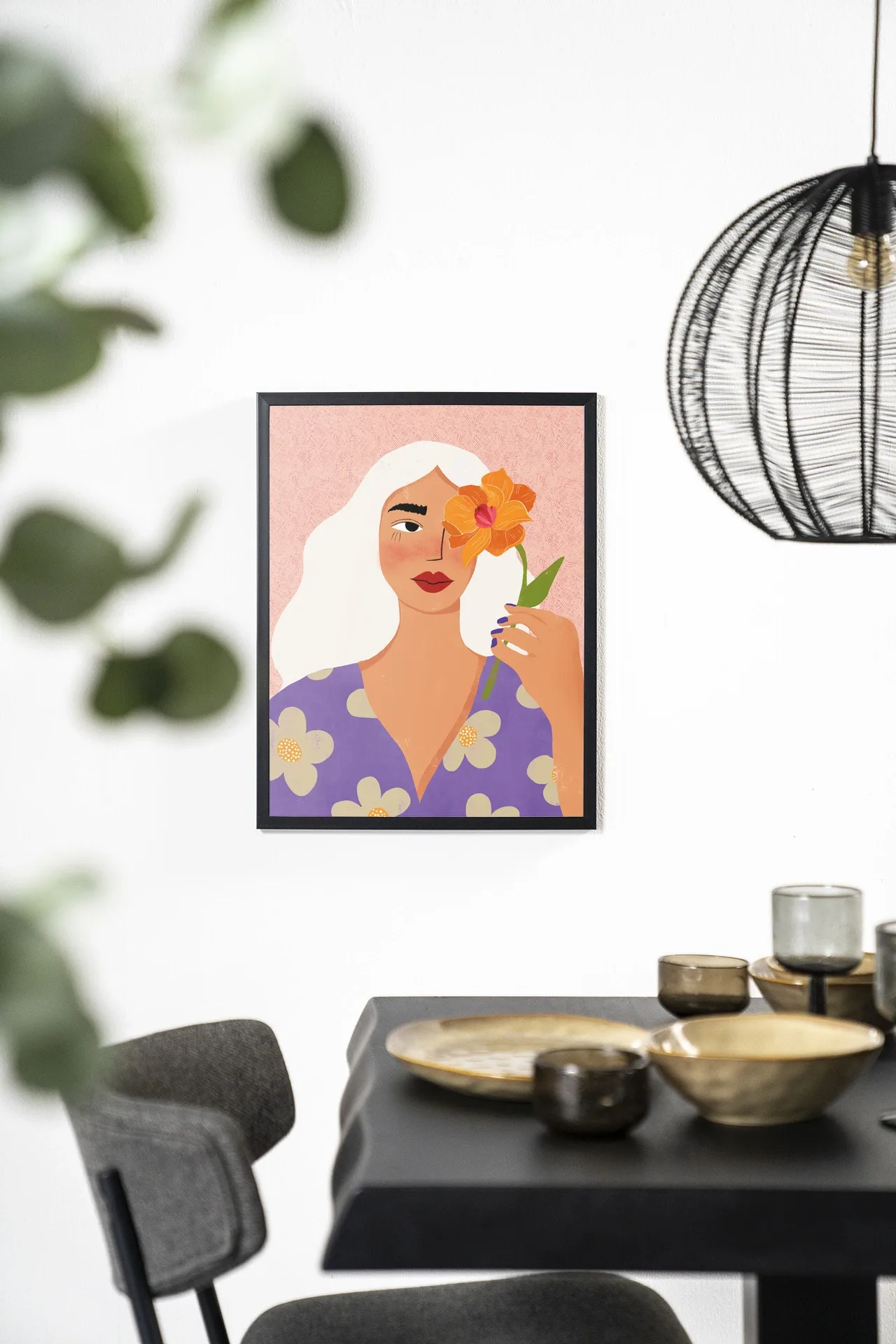 Wandteppich Flower Girly - Urban Cotton hängt an einer weißen Wand über einem schwarzen Tisch
