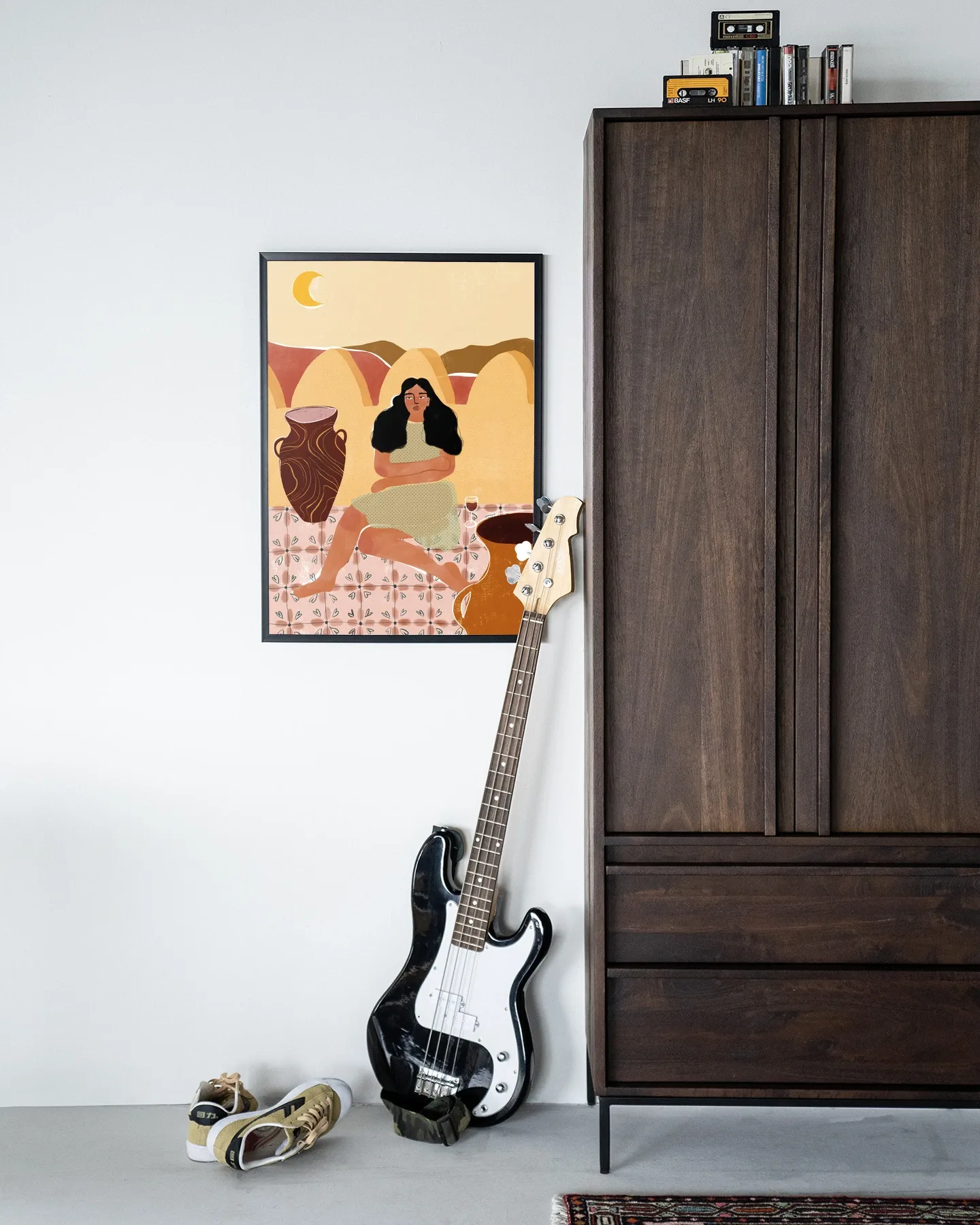 Wandteppich Paradise Found - Urban Cotton hängt an einer weißen Wand neben einem dunkelbraunen Schrank mit einer Bassgitarre und Schuhen davor