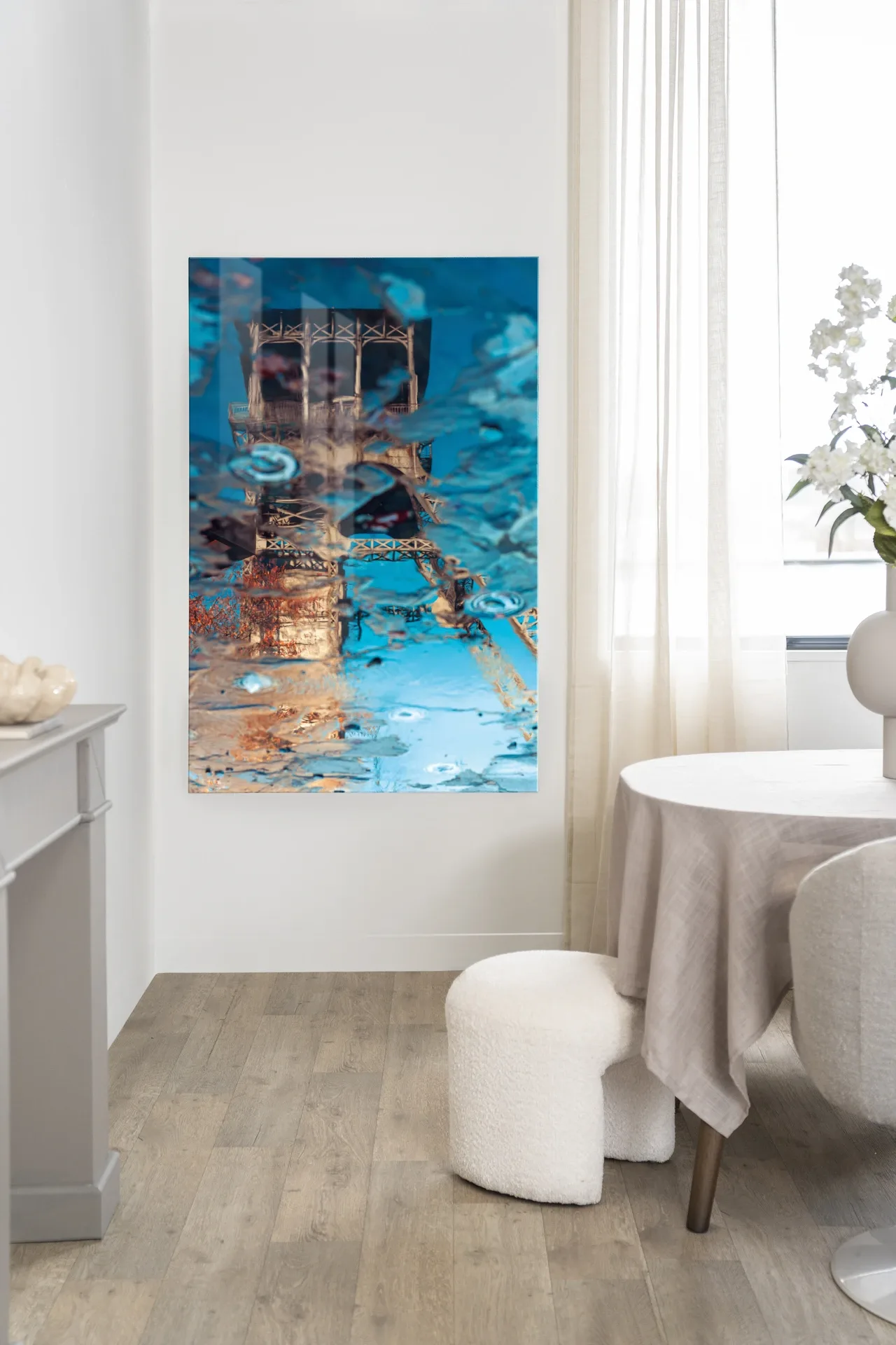 Wandteppich Mirror Me - Urban Cotton hängt in einem hellen Raum über einem weißen Pouf