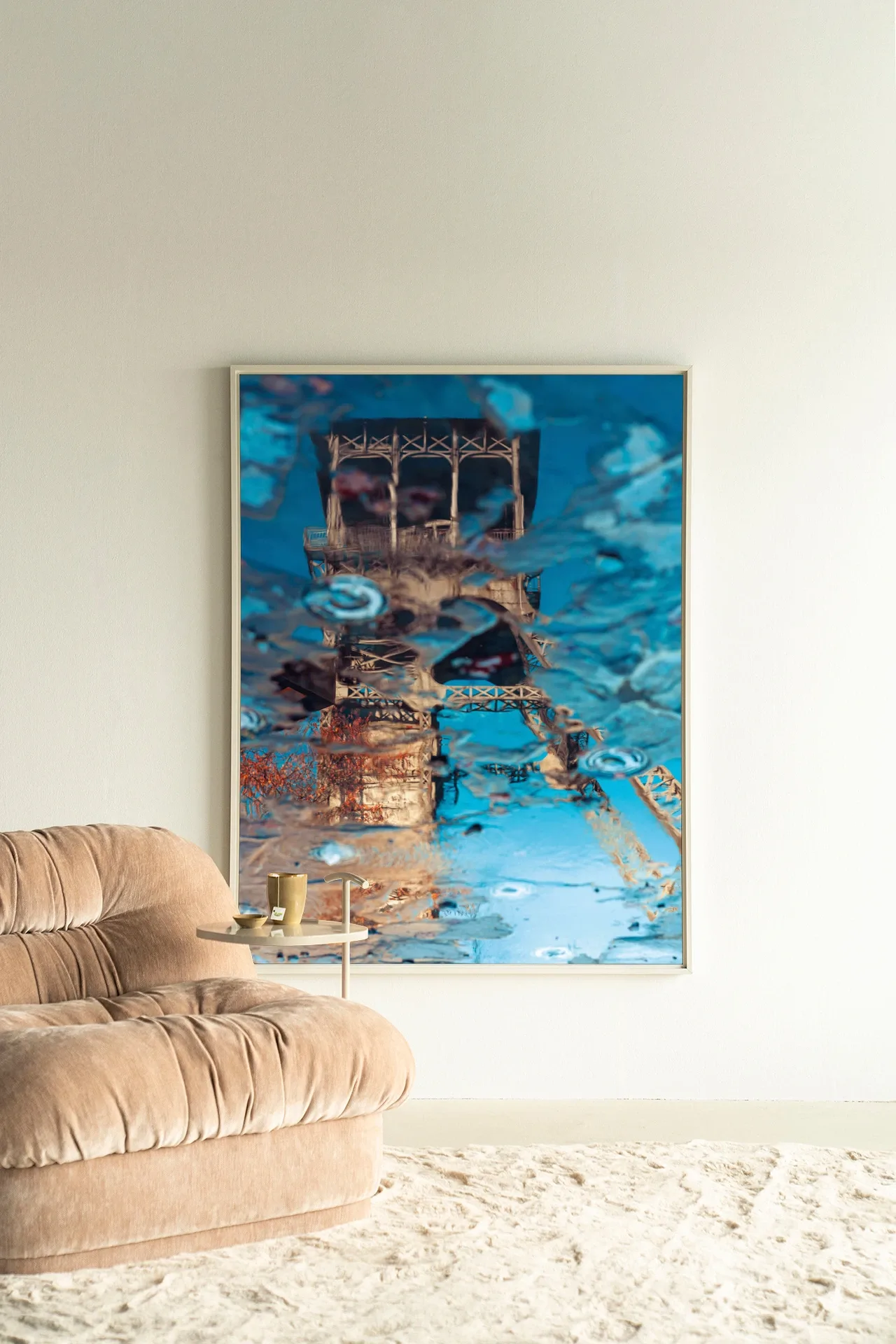 Wandteppich Mirror Me - Urban Cotton hängt an einer weißen Wand neben einem beigen Sessel