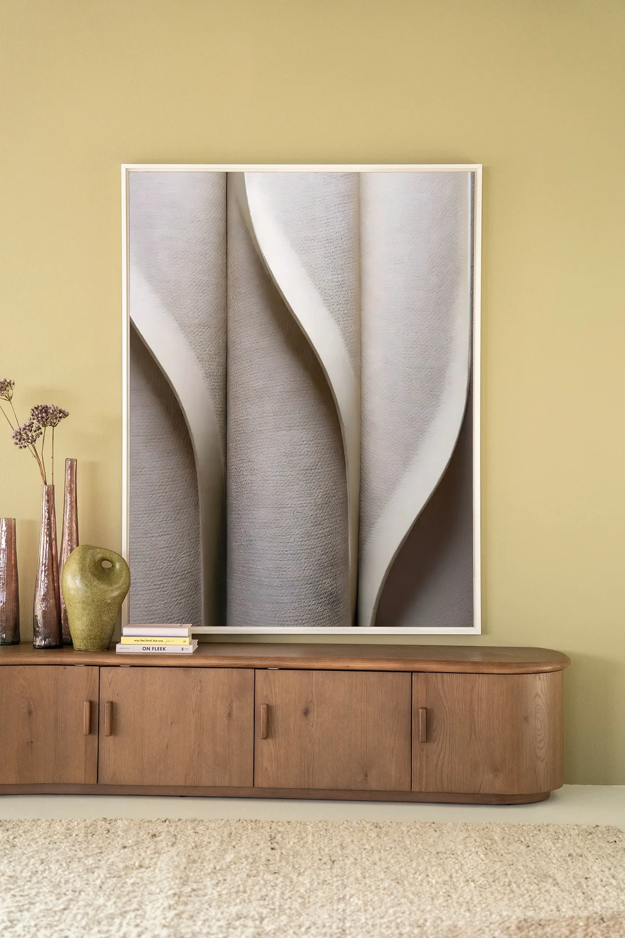 Wandteppich Silent Waves - Urban Cotton hängt über einem Holzbuffet mit Vasen und Büchern