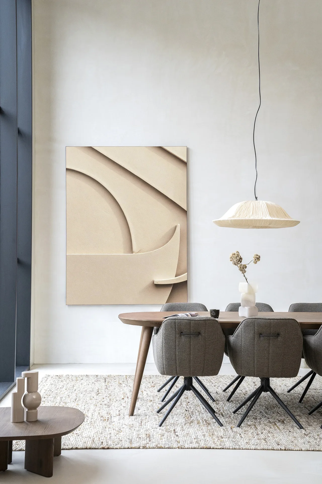 Wandteppich Siaa 1 - Urban Cotton hängt an einer weißen Wand über einem Holzesstisch