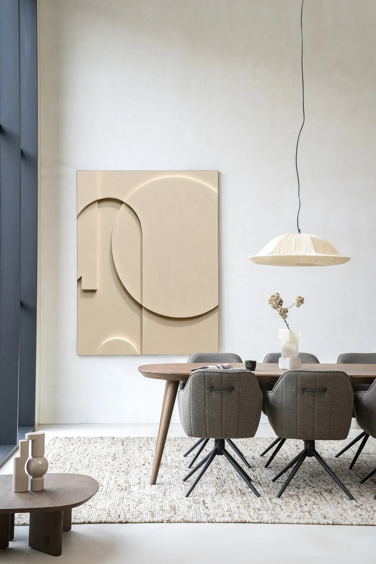 Wandteppich Siaa 3 - Urban Cotton hängt an einer hellen Wand in einem modernen Esszimmer mit Holztisch
