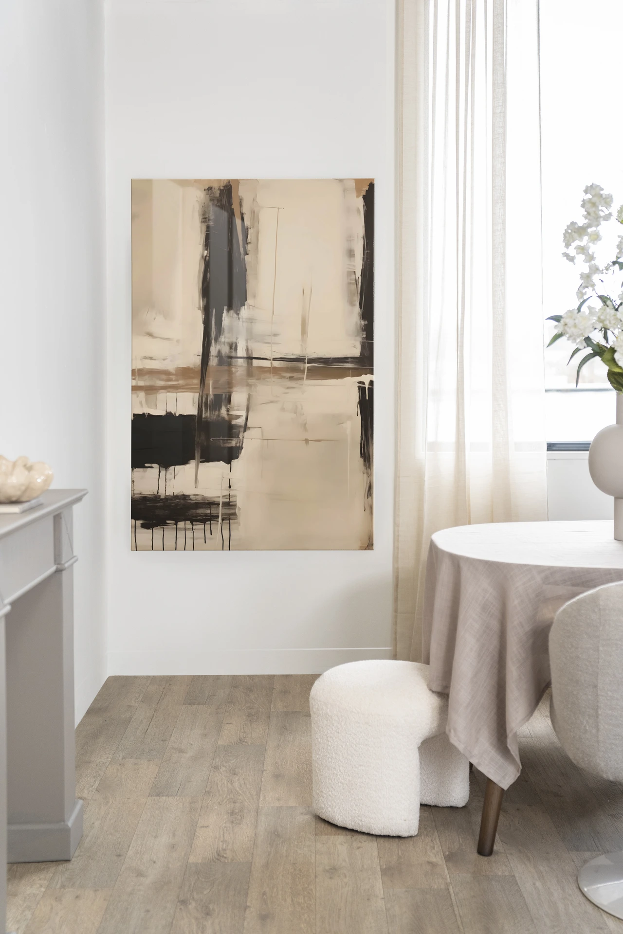 Wandteppich Noire von Urban Cotton in einem hellen Wohnzimmer mit Esstisch und Pouf