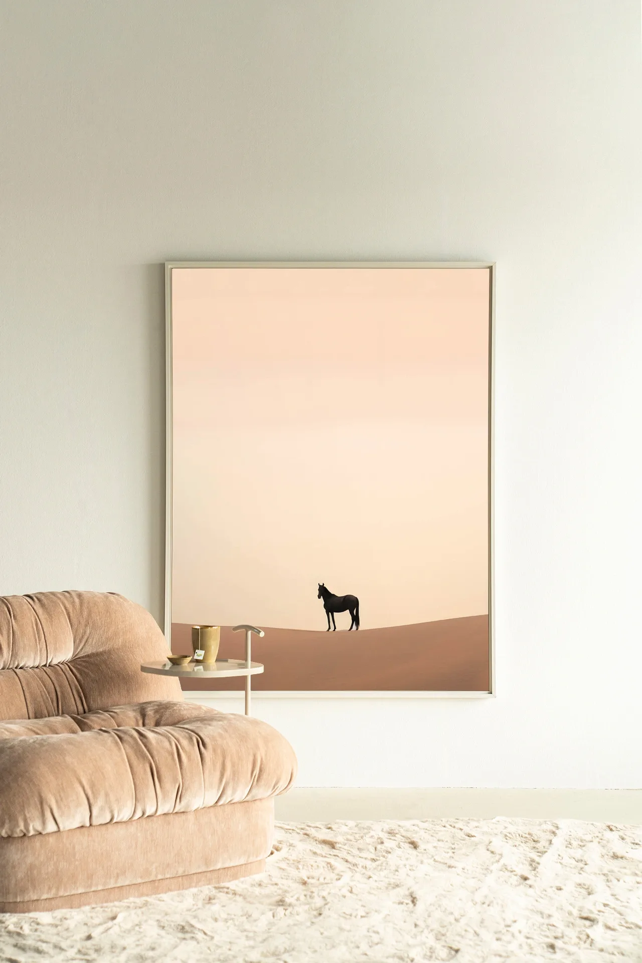 Ein Wandteppich Desert Horse - Urban Cotton hängt an einer hellen Wand neben einem beigefarbenen Sofa