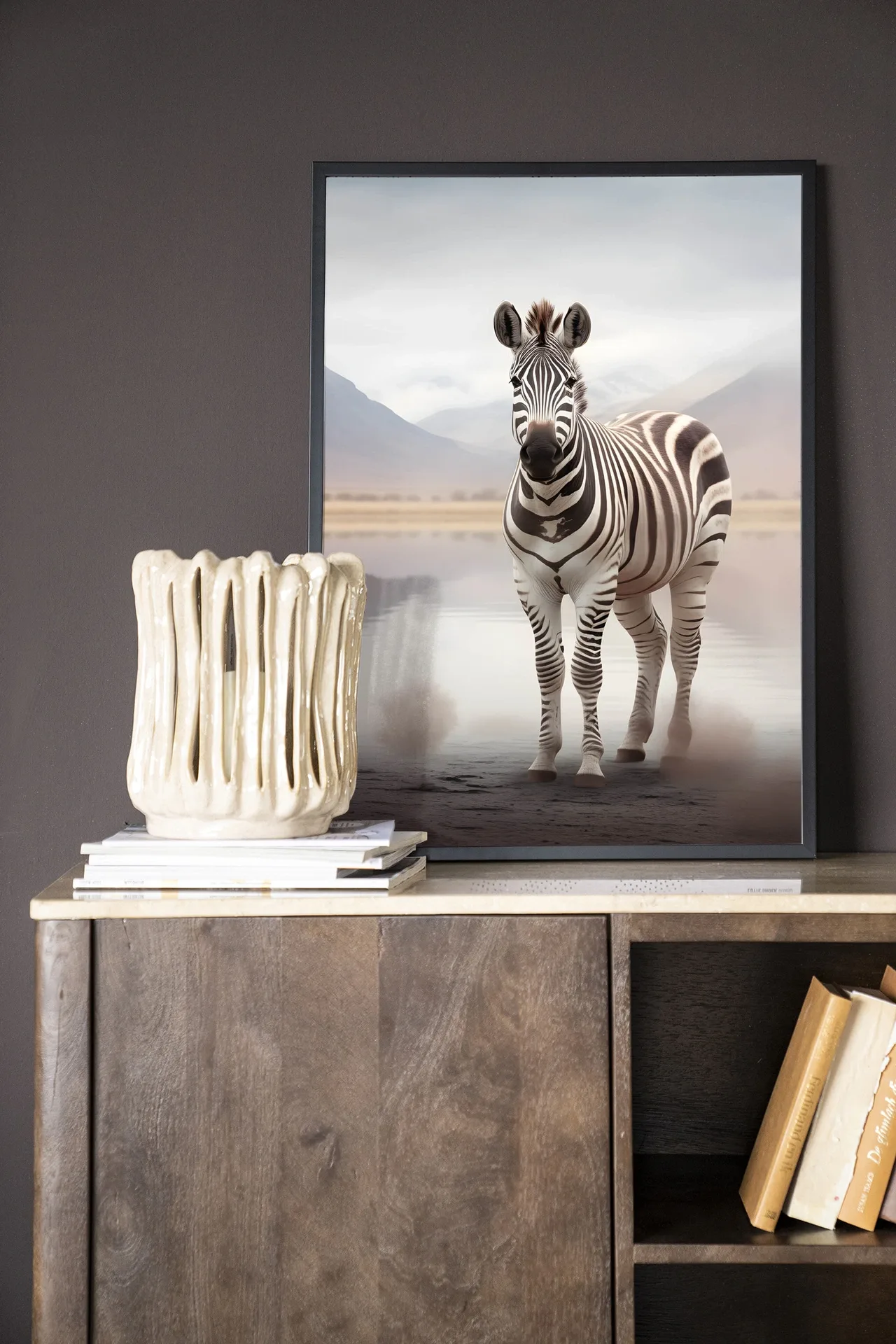 Wandtuch Zebra Mist - Urban Cotton hängt an einer dunkelgrauen Wand über einem Sideboard aus Holz mit Dekoration