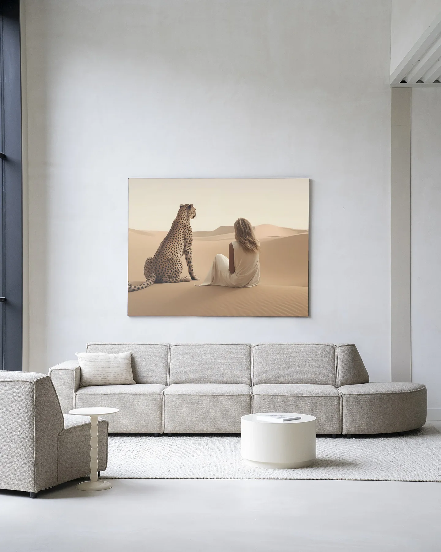 Ein Wandtuch mit einer Frau und einem Geparden in der Wüste, das über einem beigen Sofa in einem hellen Wohnzimmer hängt - Urban Cotton