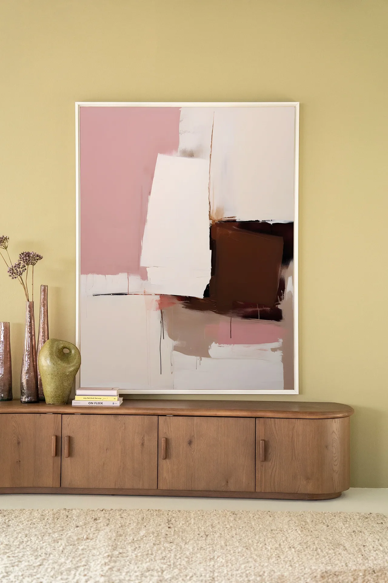 Wandteppich Pink Fields - Urban Cotton hängt über einem Holzsideboard mit Vasen und Büchern