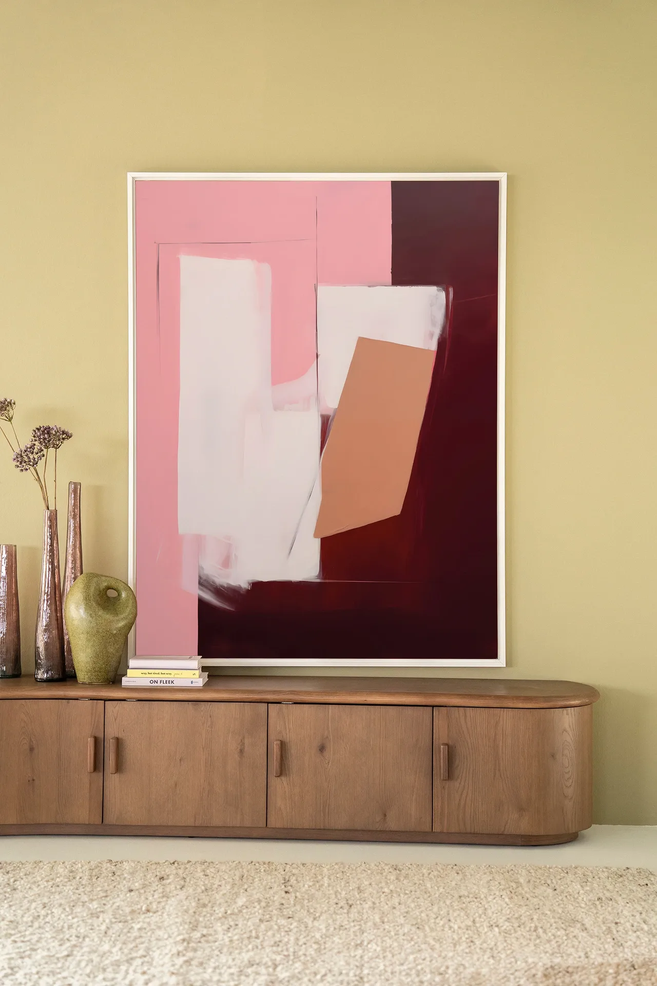 Wandteppich Red Fields - Urban Cotton hängt über einem Holz Sideboard mit Vasen und Büchern